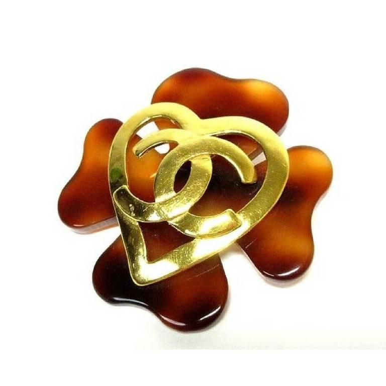 1990s. Vintage CHANEL plastic marble brown flower petal brooch with golden heart CC motif on top.

Fun and Chic and Gorgeous jewelry piece from CHANEL! 
Great gift idea. Free gift wrapping. 

90's vintage Chanel brooch in adorable and unique heart