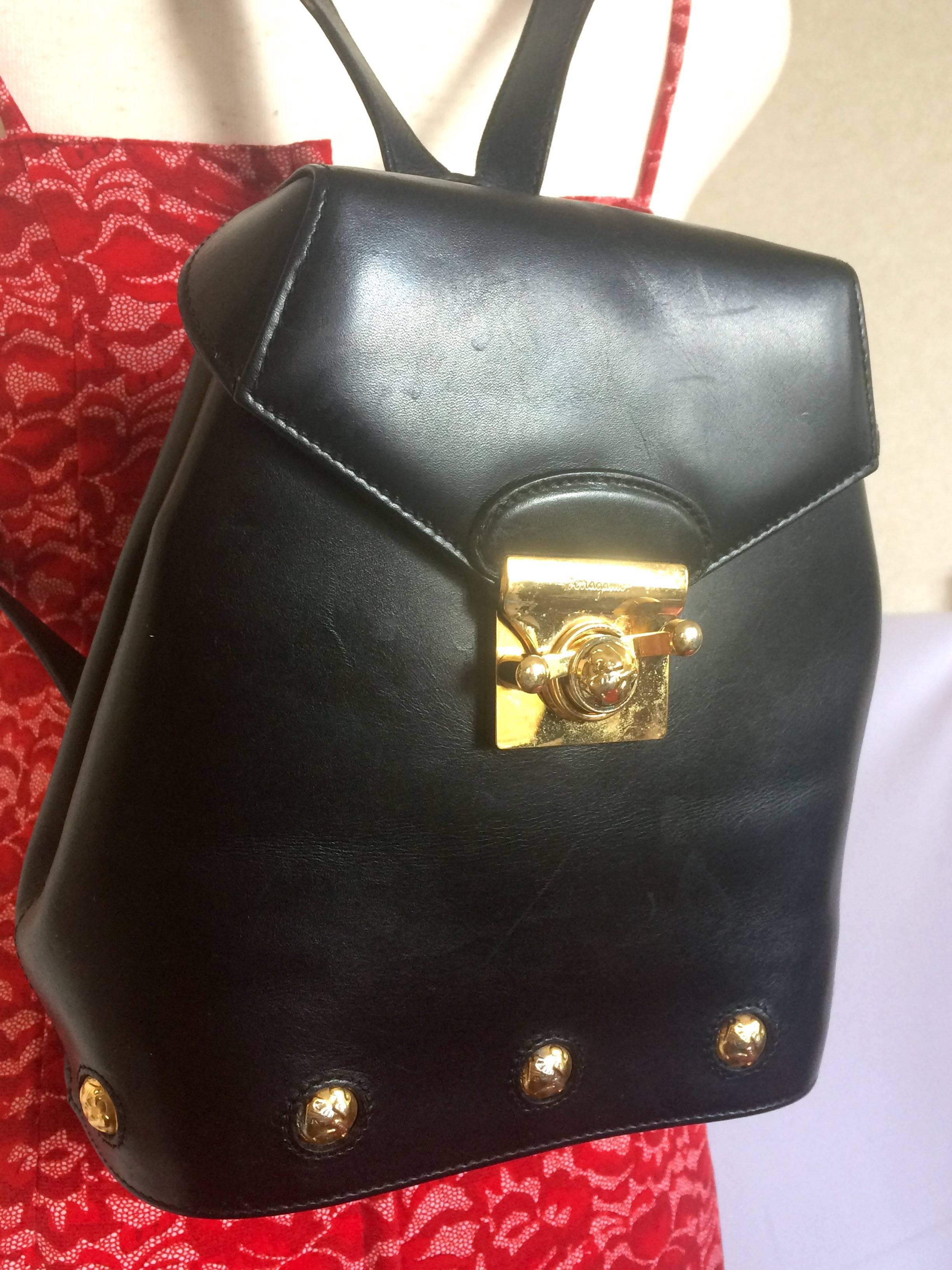 1990s. Vintage Salvatore Ferragamo black calf leather backpack with golden motif closure and shoe engraved motifs. Rare masterpiece.

Introducing another rare masterpiece from Salvatore Ferragamo black genuine leather backpack with gold tone