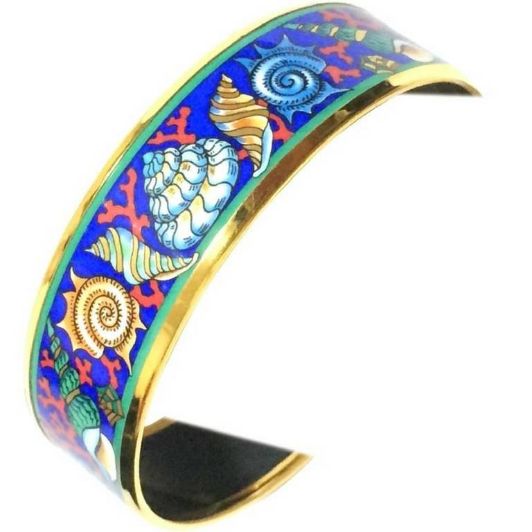 1990s. Vintage Hermes cloisonne enamel blue ocean, sea, yellow, brown, blue colorful shell, pink coral design golden thick bangle.
Introducing a fantastic jewelry piece  from HERMES....
The iconic cloisonne enamel golden bangle! Perfect jewelry