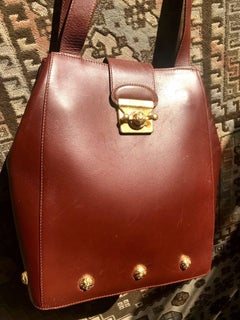 Vintage Salvatore Ferragamo brown shoulder bag with golden motifs and closure.