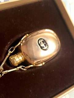 Vintage Gucci golden perfume bottle necklace with logo mark on top.