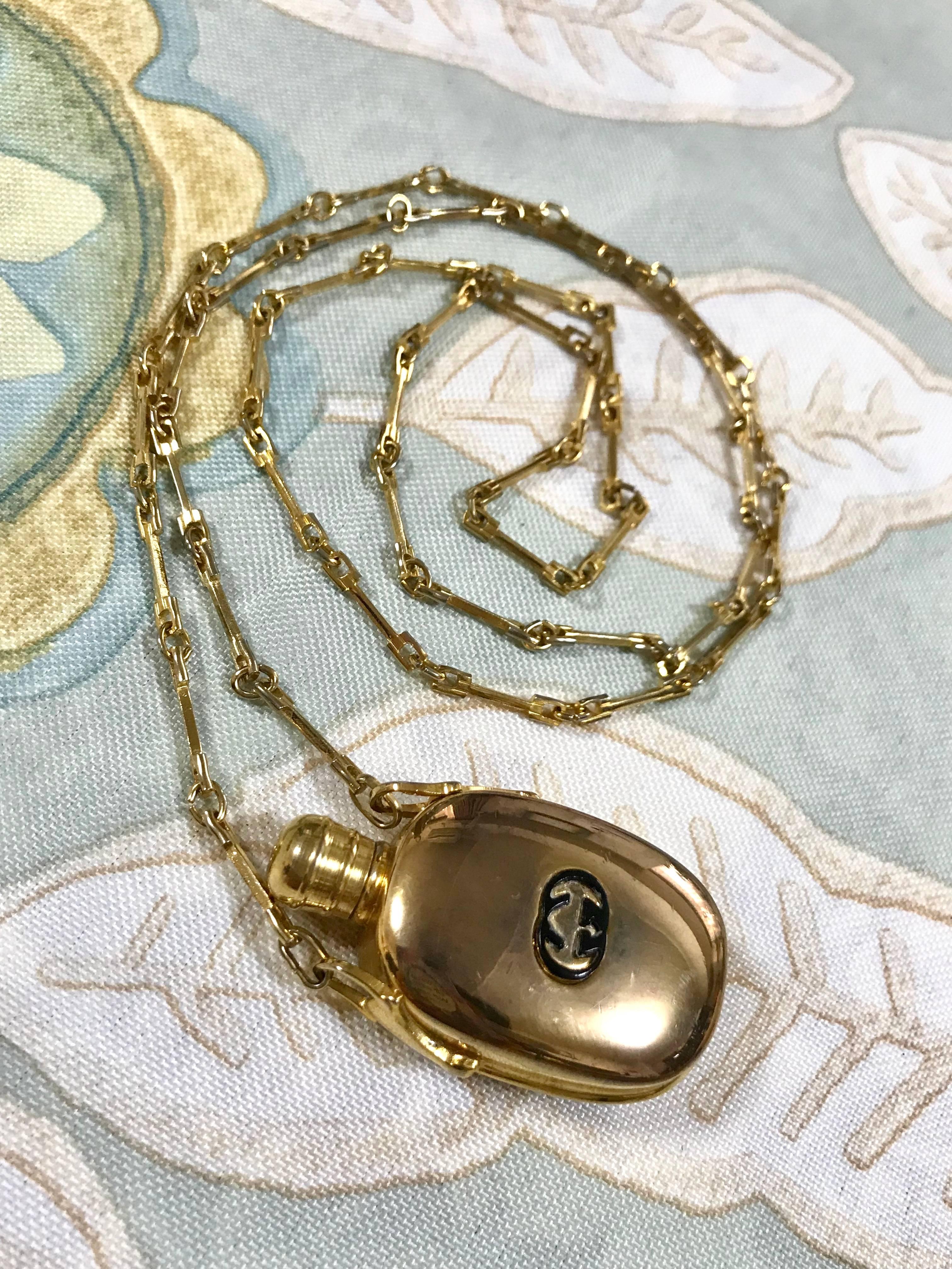 Women's or Men's Vintage Gucci golden perfume bottle necklace with logo mark on top. 