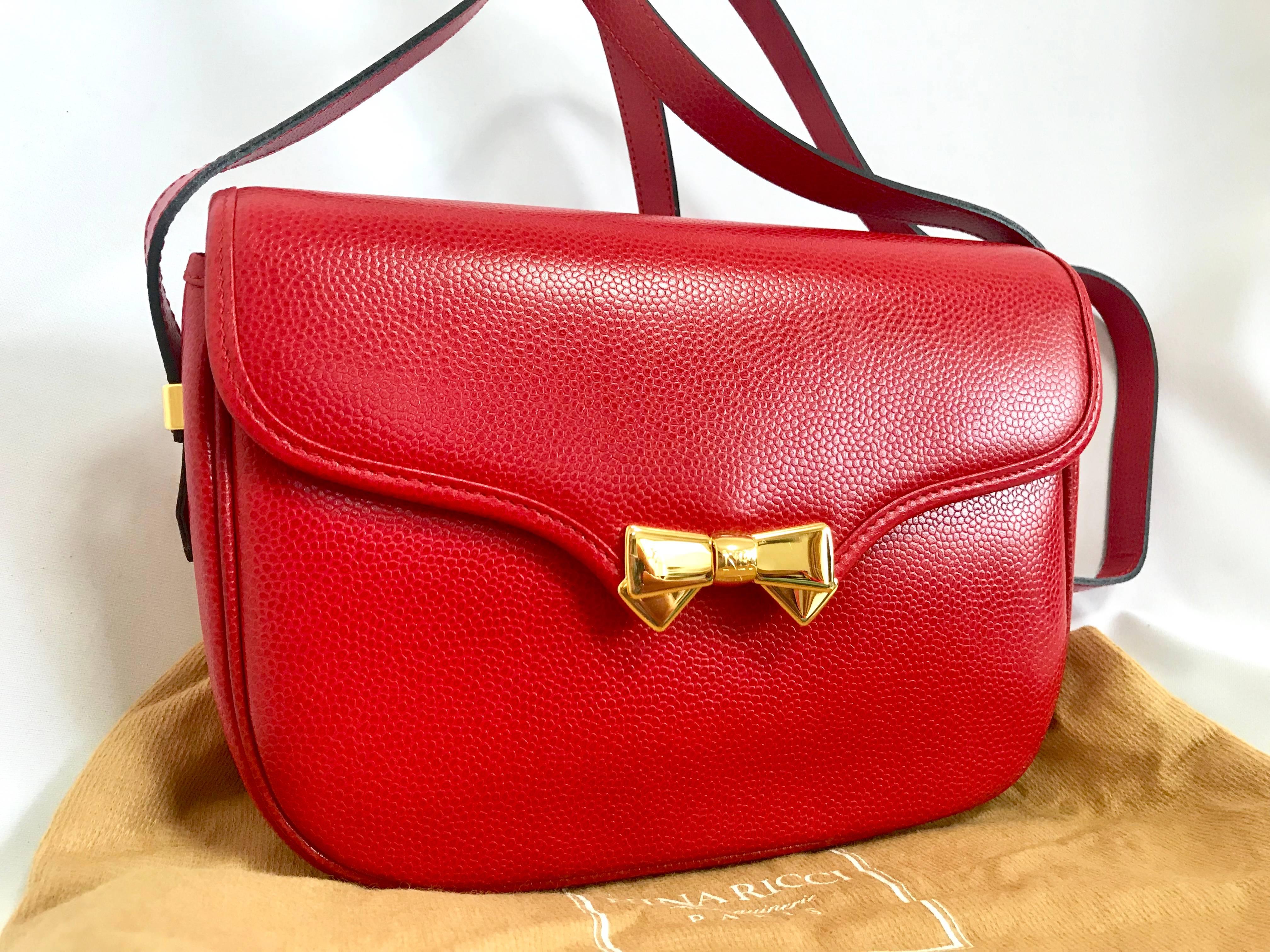 1990s. MINT. Vintage Nina Ricci red grained leather shoulder bag with golden logo bow motifs. So chic. Must have daily purse.

This is a vintage NINA RICCI, cute shape red leather shoudlet purse with golden bow logo motifs! NEW/ Never used excellent