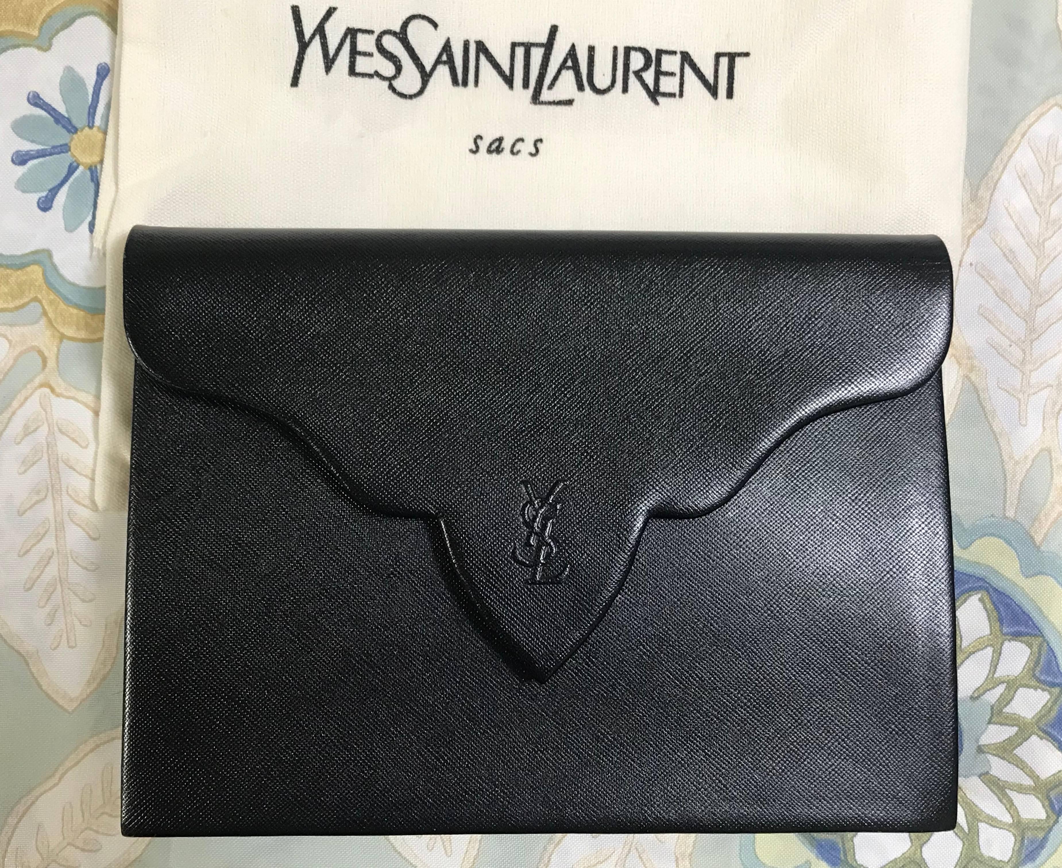 1990s. Vintage Yves Saint Laurent genuine black leather clutch purse with beak tip flap and logo stitch motif. 

This is a vintage genuine leather clutch bag from Yves Saint Laurent in approximately from the 90s.  
Great to be one of your