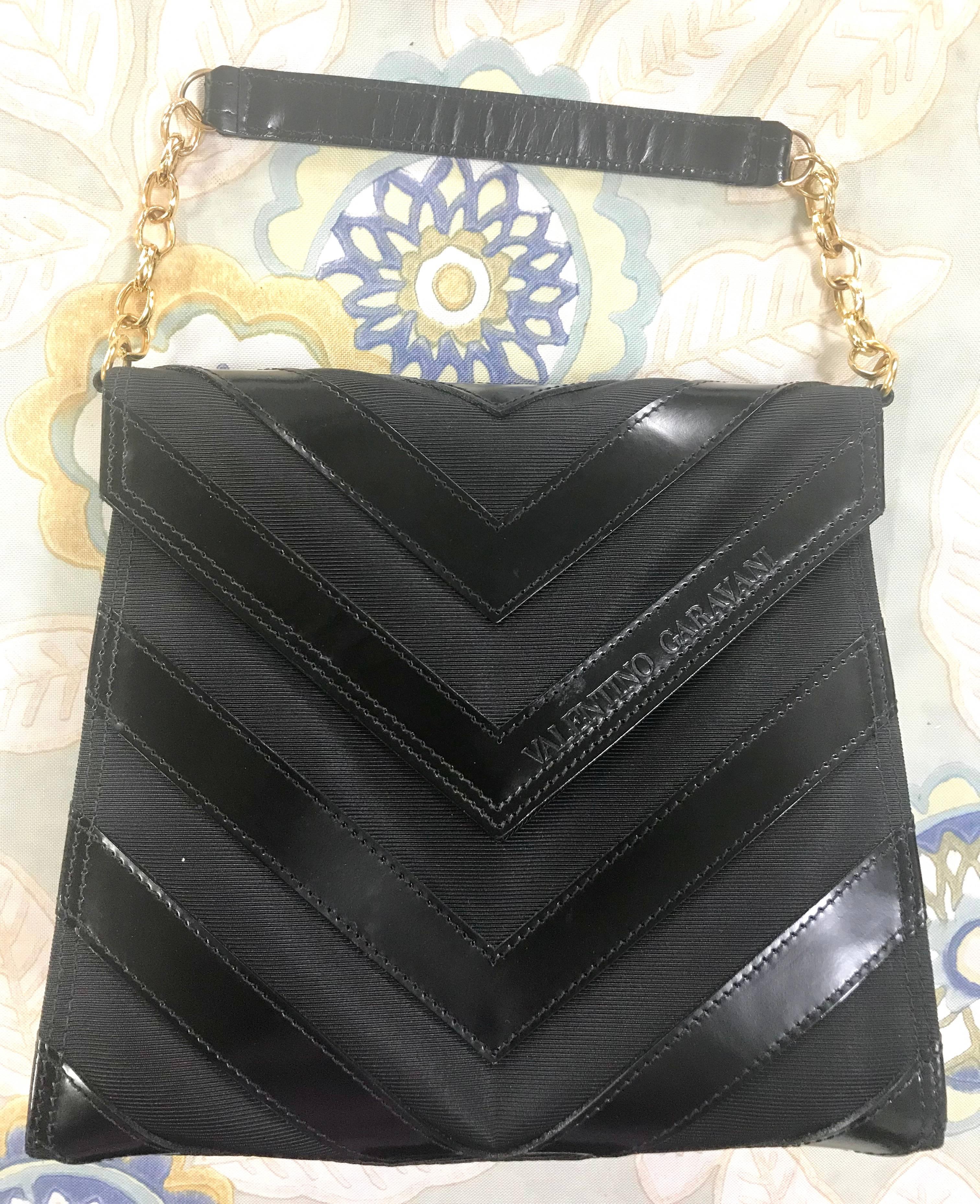 1990s. Vintage Valentino Garavani black enamel leather and fabric combo V/chevron front design handbag with chain strap.

Introducing another beautiful vintage handbag from Valentino Garavani back in the 90's.

This enamel chevron stitch front