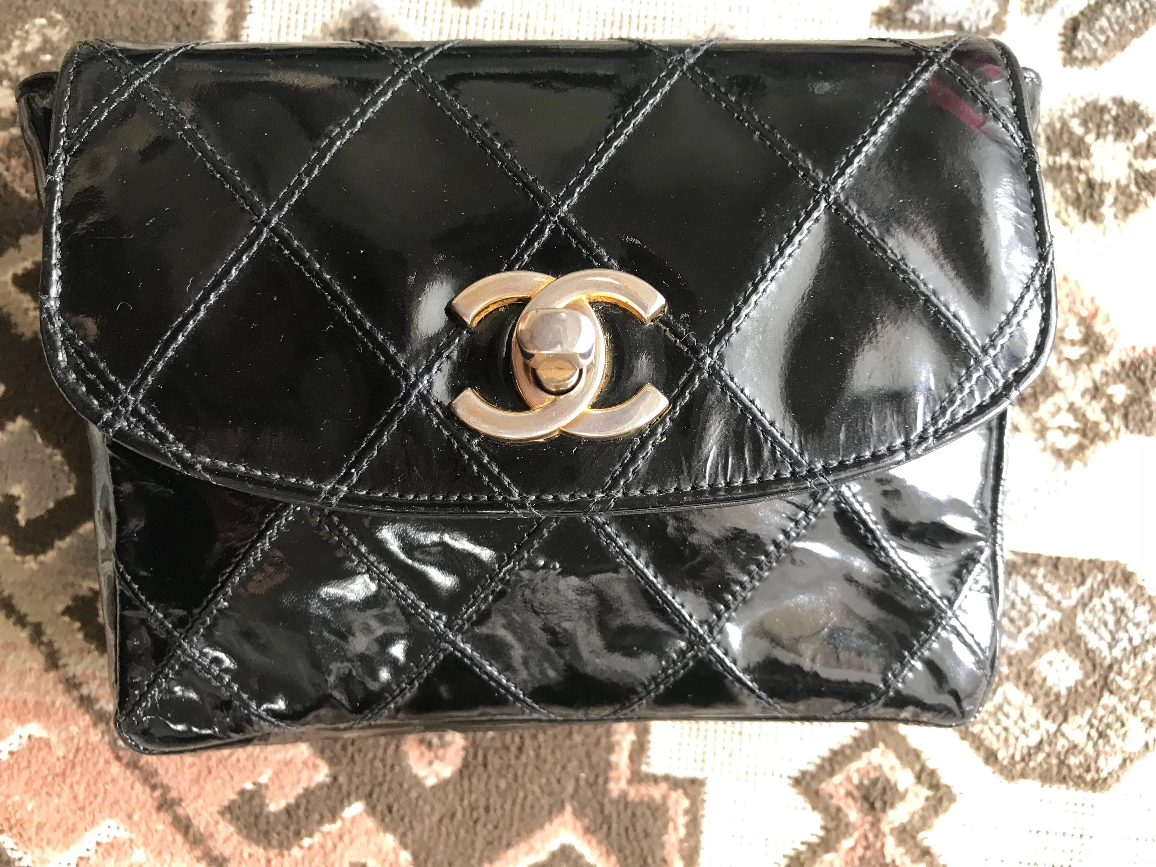 1990s. Vintage CHANEL black patent enamel leather waist purse, fanny pack with matching belt. Belt size 28.15” through 30.3”(71.5cm through 77cm).

Introducing a vintage CHANEL classic black enamel purse, fanny pack with gold tone CC closure. 
The