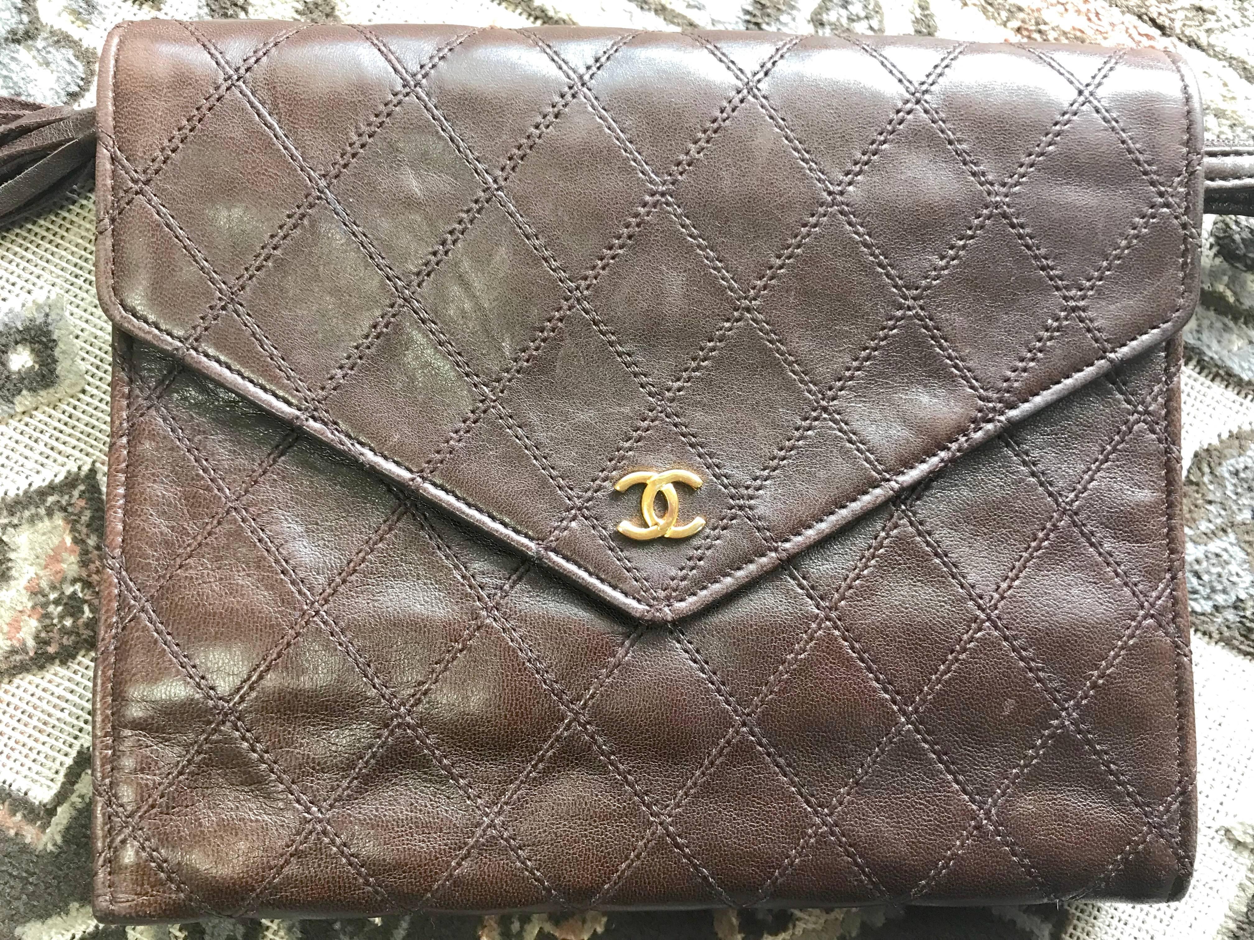 1980s. Vintage CHANEL brown goatskin clutch bag, large wallet, bill, checkbook, iPhone purse with a tassel and golden mini CC motif. Unisex use.

Introducing a CHANEL vintage functional wallet in dark brown goatskin from the 80s.
Wallet, iPhone