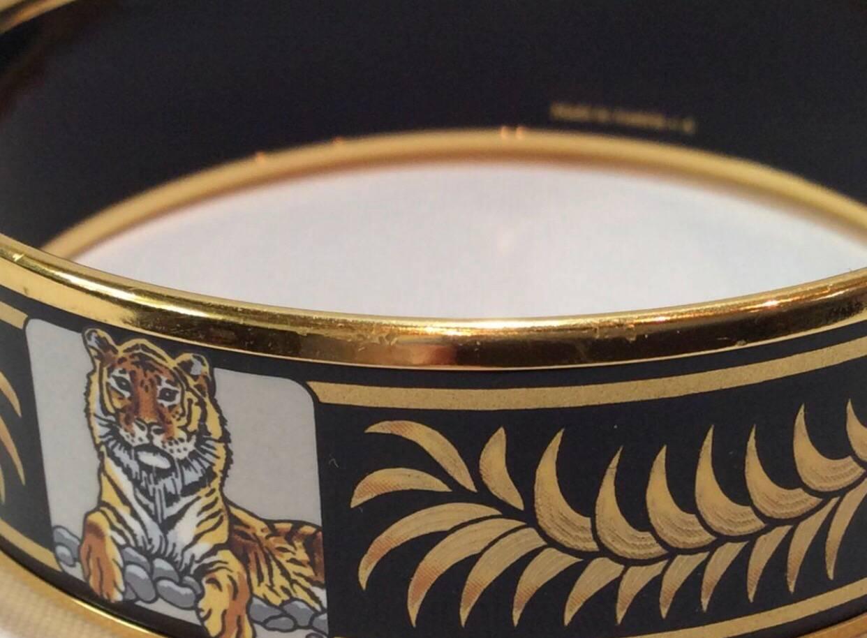 1990s. Vintage Hermes black cloisonne enamel golden thick bangle, bracelet with tiger and leaves design in black and gold. 

Introducing another masterpiece jewelry piece from HERMES back in the 90's, 
iconic enamel/cloisonne gold plated bangle