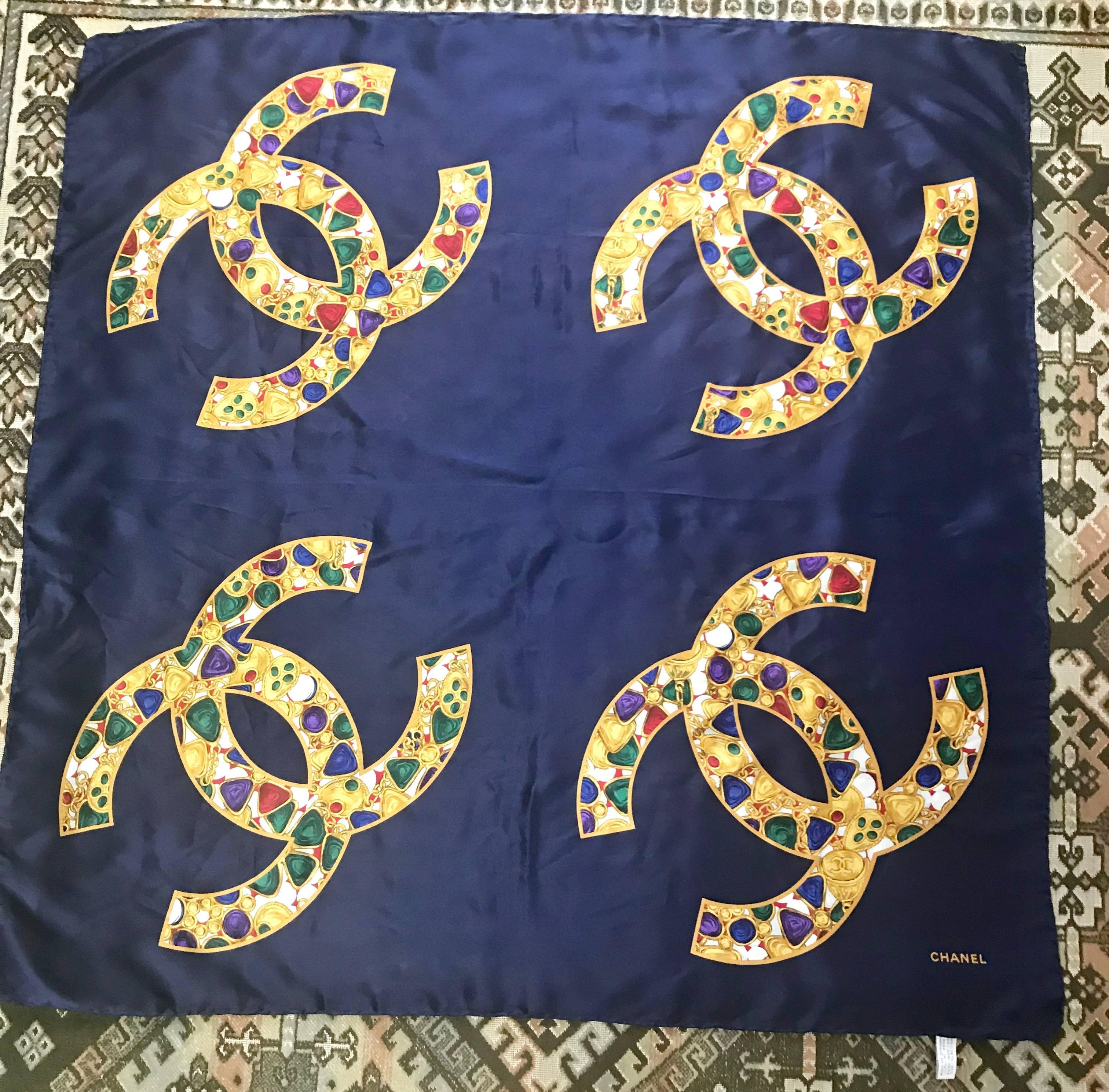 1990s. Vintage CHANEL large navy 100% silk scarf with gold, red, purple, green, multicolor Gripoix, chain, jewelry print in 4 CC marks Gorgeous wrap.

This is a 100% silk scarf from CHANEL in the 90's. 
Very nice and soft silk wrap....

With