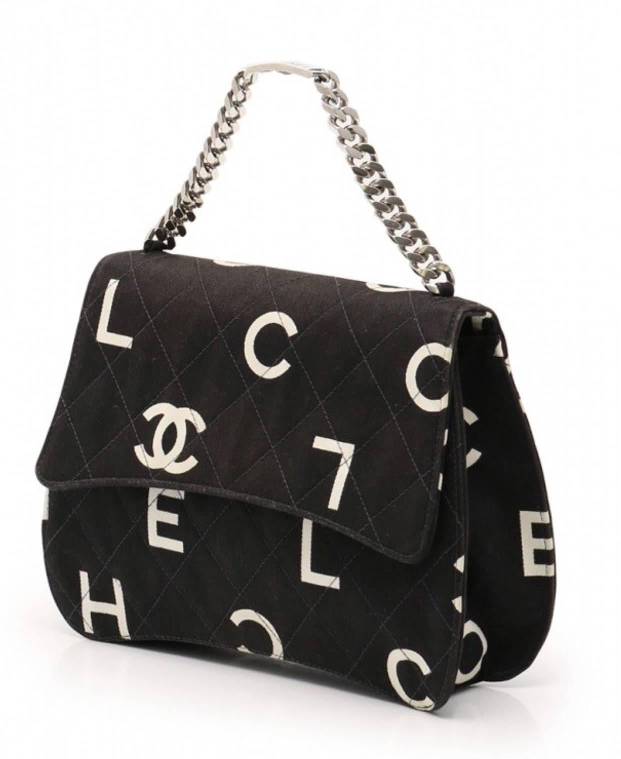 1990s. Vintage CHANEL black fabric canvas handbag with silver tone chain strap and white Chanel CC logo print all over. Very unique shape. Must have. 

Introducing one of the most chic and mod CHANEL purses back in the 90's!
Black canvas with white