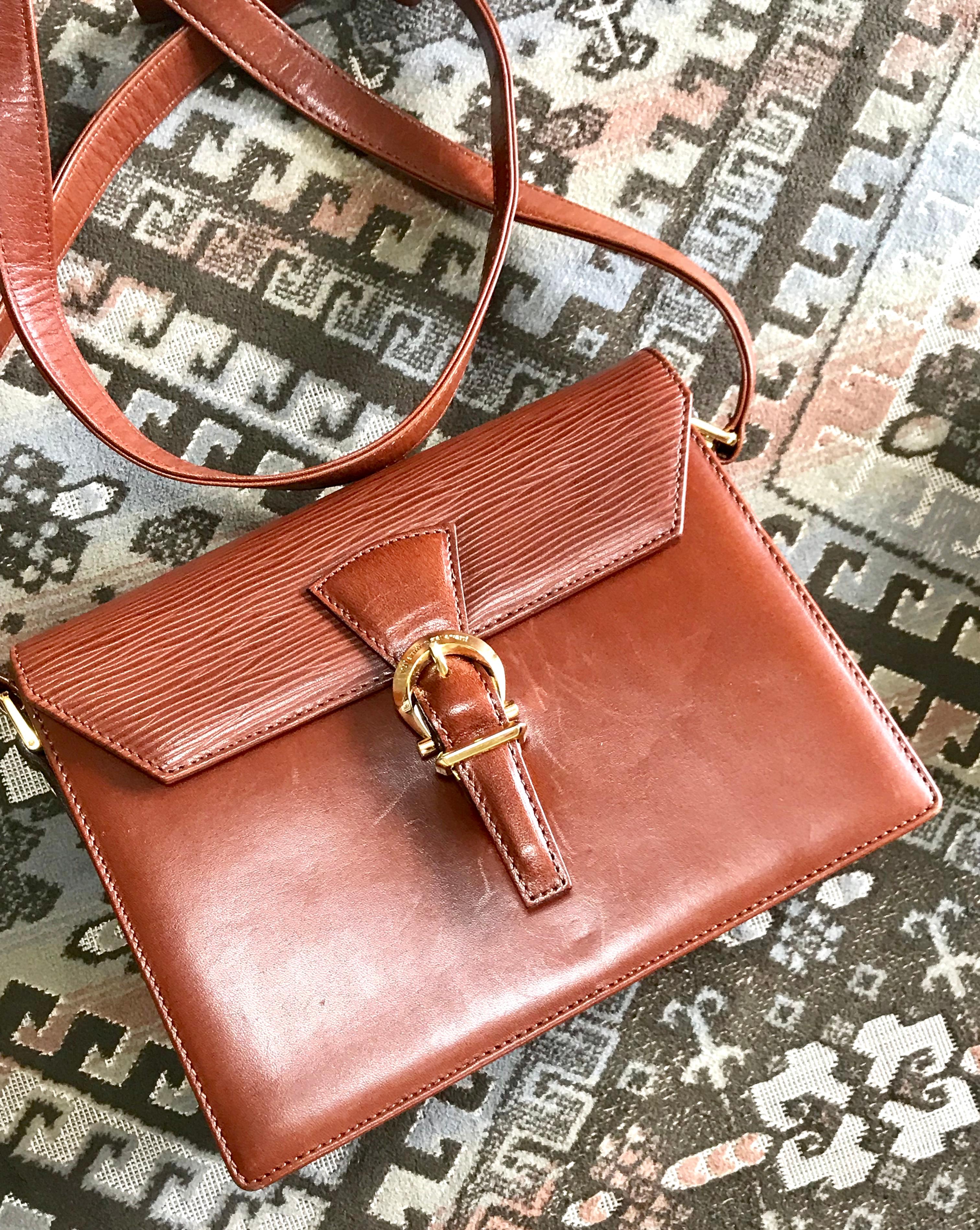 1990s. Vintage Valentino Garavani brown epi leather shoulder bag with golden logo buckle design closure. Classic Valentino purse for any occasions.

This is the vintage Valentino Garavani brown leather shoulder bag from approx. early-mid
