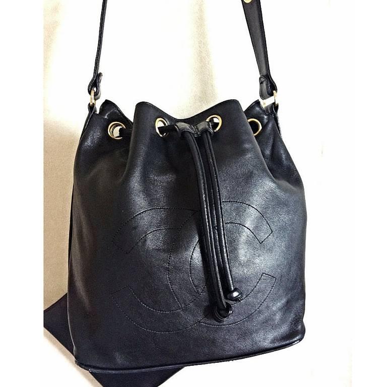 Vintage CHANEL black lamb leather hobo bucket shoulder bag with drawstrings and CC stitch mark. Classic purse.

Introducing another adorable vintage masterpiece from CHANEL back in the early 90s.
Black bucket hobo shoulder bag in lamb leather.