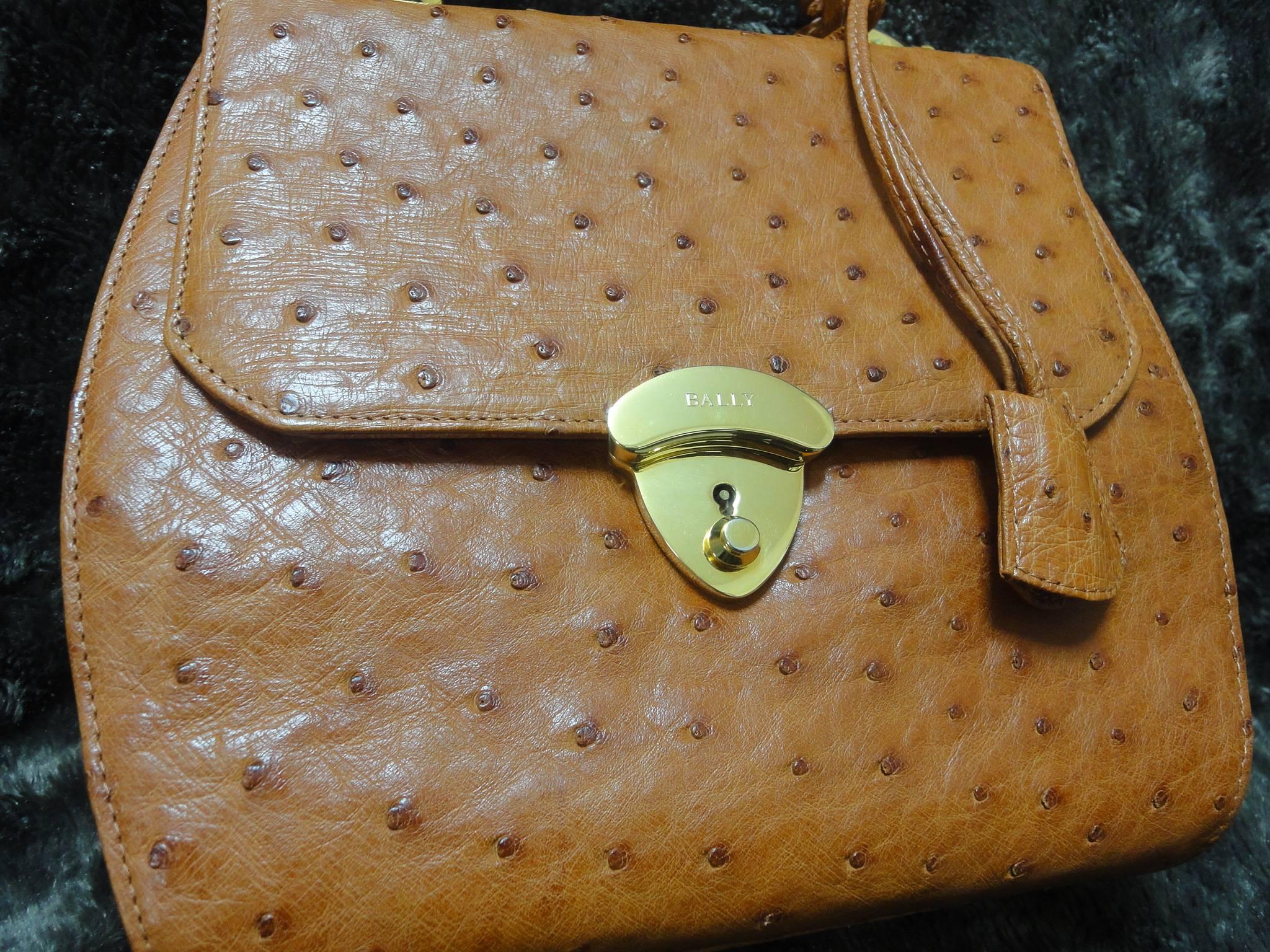 MINT. Vintage BALLY genuine ostrich leather orange brown handbag with shoulder strap and mirror.

This is a vintage Bally genuine ostrich leather shoulder bag in classic style from the early to mid 90s. Beautiful color!

Featuring the gold tone