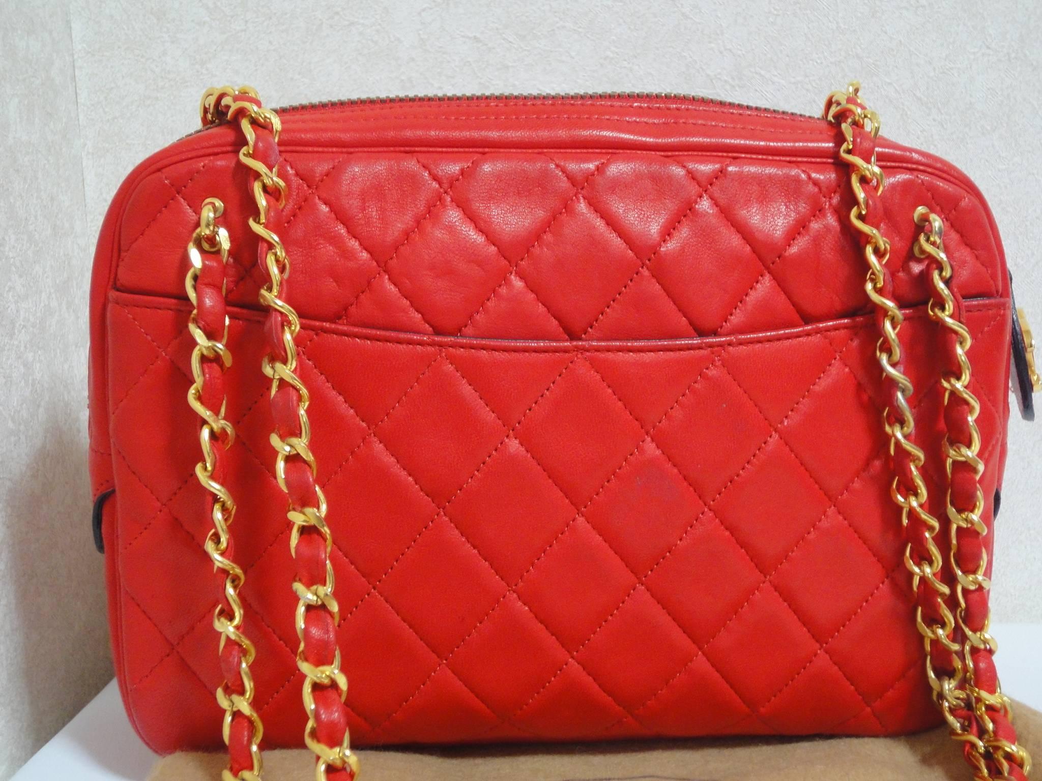 1980s Vintage CHANEL red lambskin classic shoulder purse with double gold tone chain straps and a CC pull charm.

Introducing a vintage CHANEL red lambskin purse with gold tone chain straps. 
One of the most classic and popular styles from CHANEL