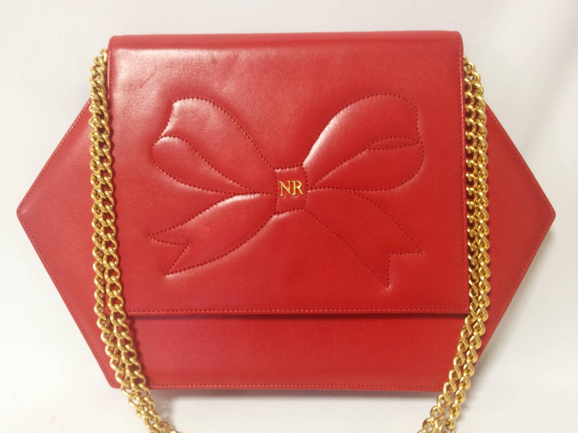 Vintage Nina Ricci red leather hexagon shape clutch shoulder bag with a large bow stitch and golden chain. Perfect party purse. Rare purse.

Introducing another cutest and rare vintage purse from Nina Ricci. A red leather chain shoulder clutch