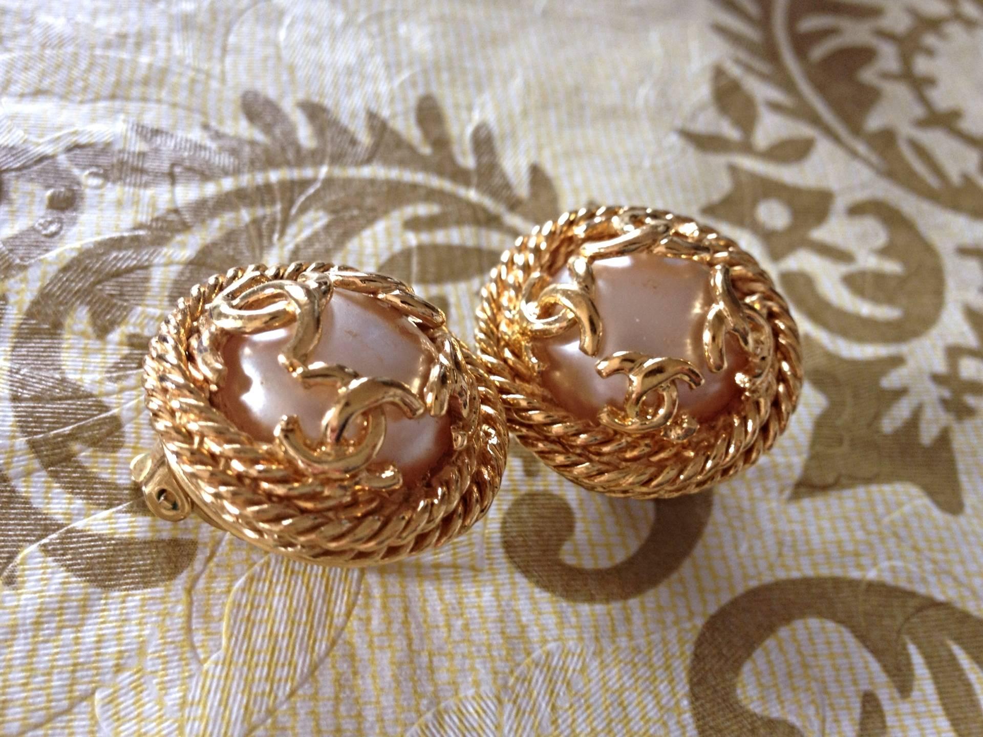 Vintage CHANEL gold tone round earrings with twisted frames, a faux pearl and CC motifs. Great and rare Chanel vintage jewelry gift.

Fun and Chic and Gorgeous CHANEL earrings for  you or your loved one!  
Great gift idea. 

Introducing a pair