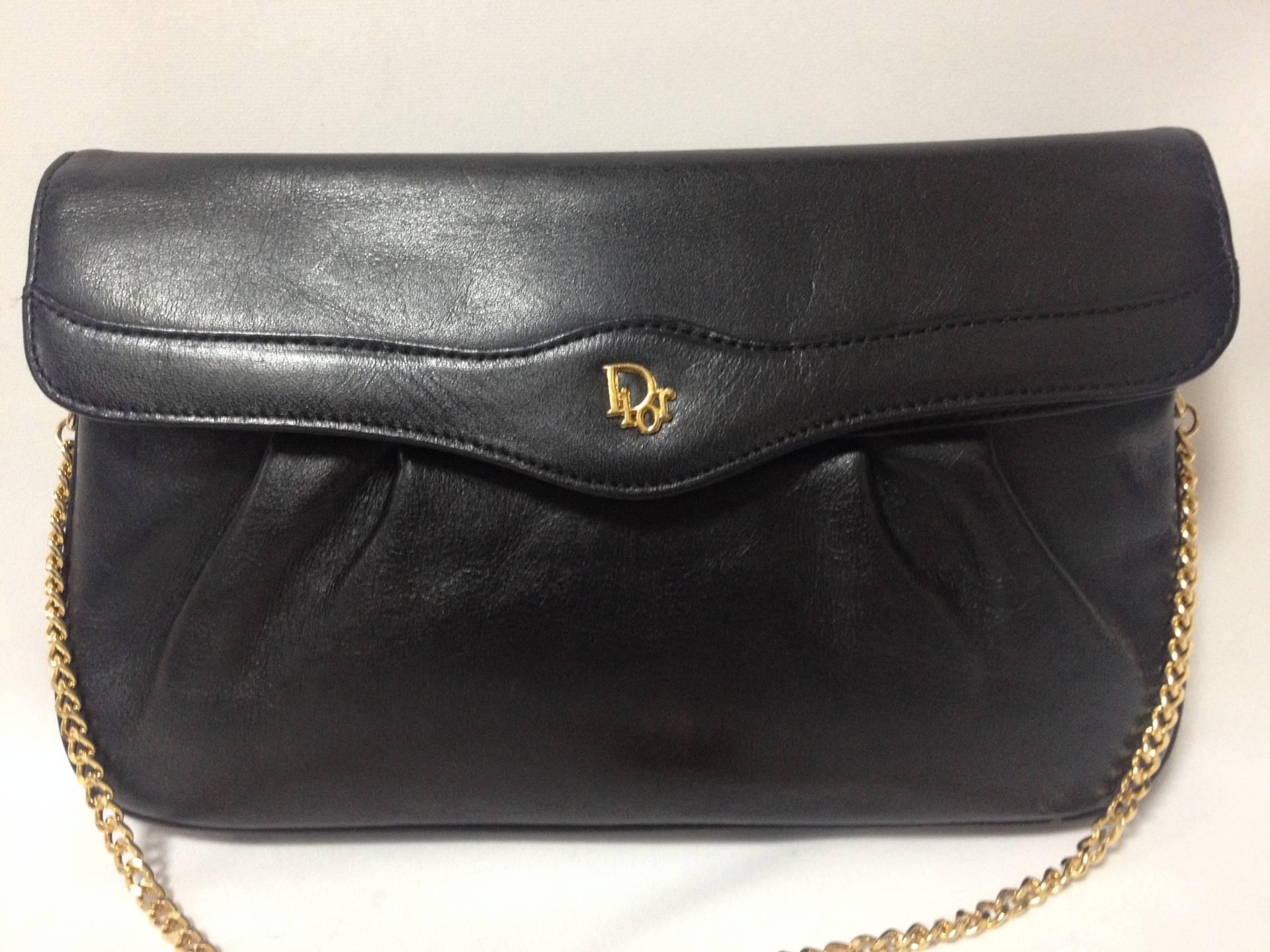 Vintage Christian Dior Vintage black leather clutch purse, mini bag, with golden Dior motif and gold tone chains.

This is a vintage black leather clutch chain shoulder purse from Christian Dior.
Featuring a golden 