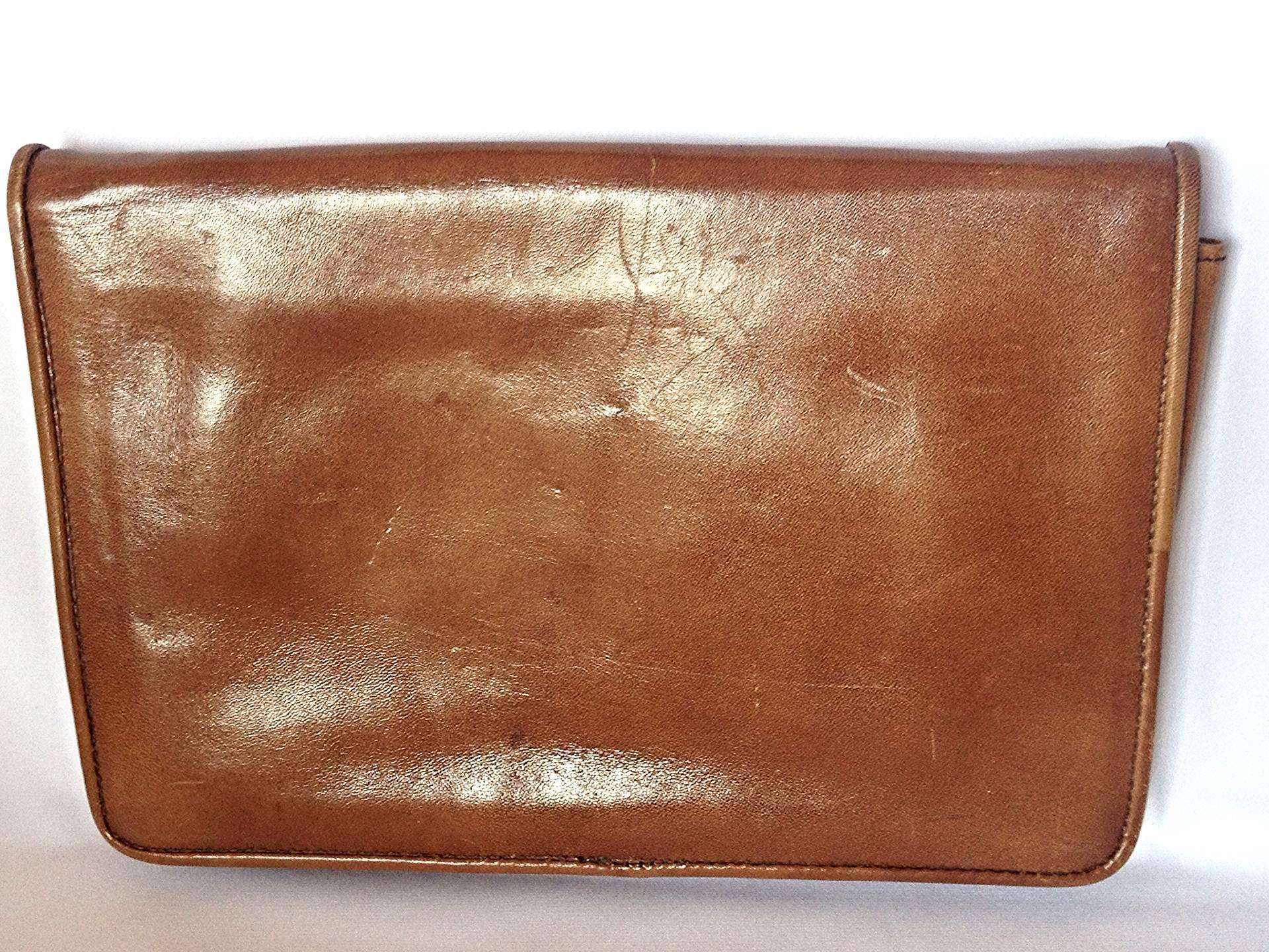 1980s vintage Yves Saint Laurent genuine brown leather mini document bag, clutch purse with embossed logo. Classic unisex style YSL purse.

This is a vintage classic design leather clutch bag from Yves Saint Laurent in approximately from the 80s. 