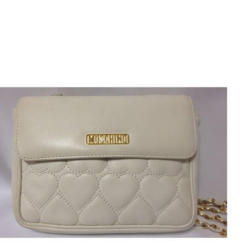 1990s. Vintage MOSCHINO white heart shape stitch lambskin shoulder purse with chain straps. Can be a hip bag and clutch handbag as well.

Introducing a chic and cute vintage piece from Moschino back in the early 90's!
You will love the heart