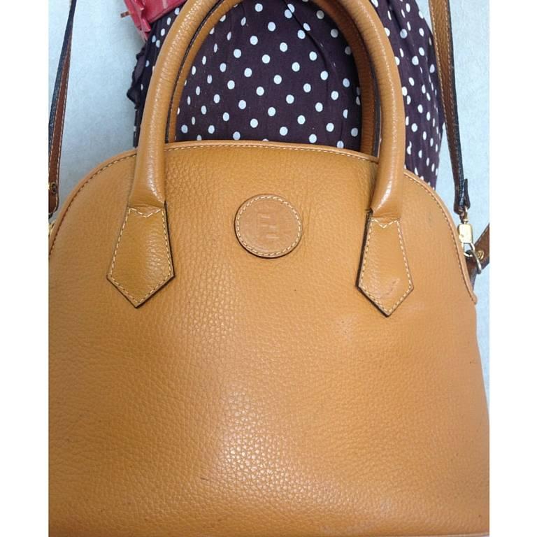 1990s. Vintage FENDI tanned brown leather oval shape, bolide style tote bag with a detachable shoulder strap and golden logo.

If you are a FENDI vintage collector and lover, then this one will be your must-have piece.

This is a vintage