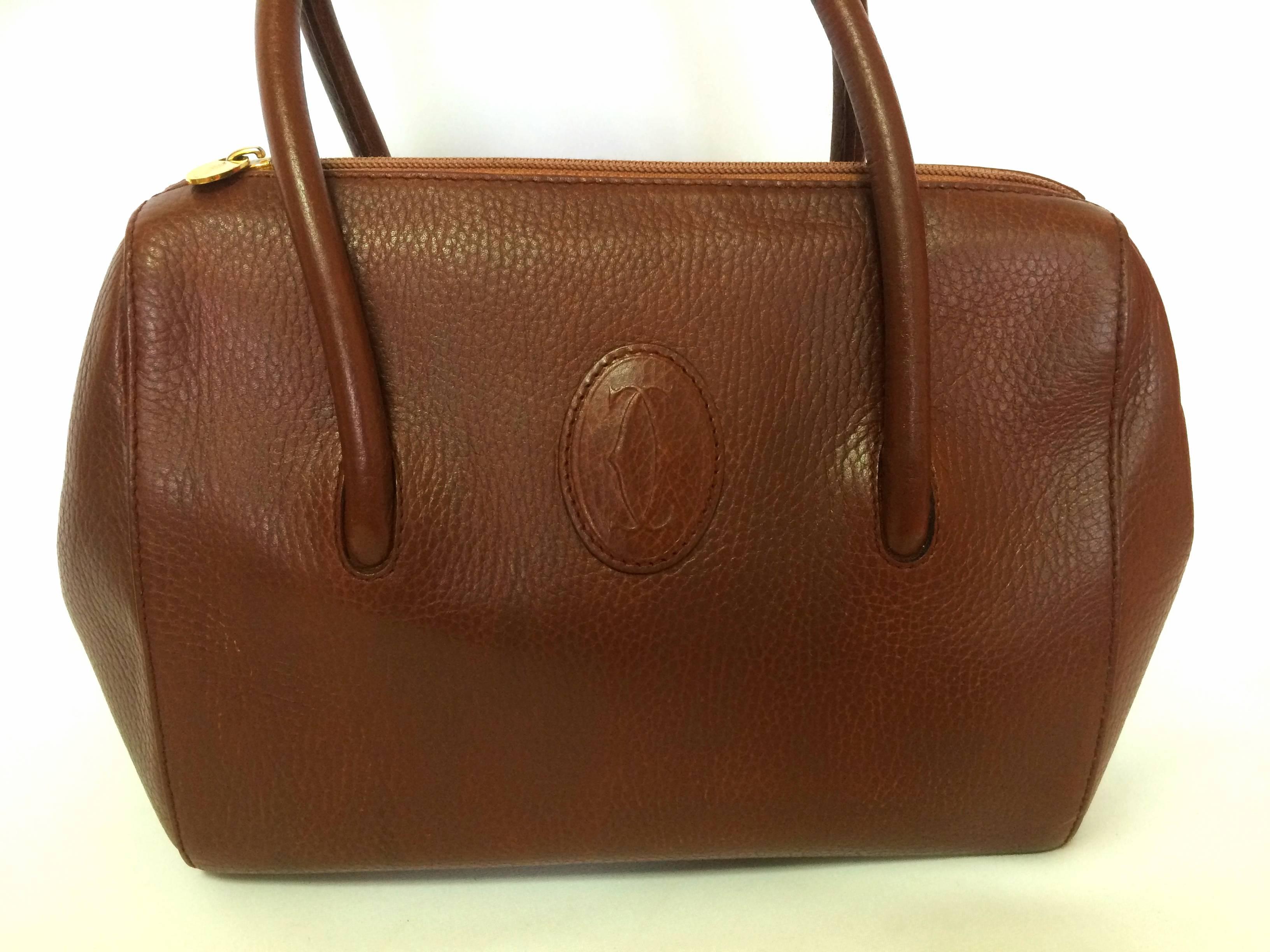 1990s. Vintage Cartier classic brown leather handbag with logo mark.  les must de Cartier collection.

Introducing a vintage brown leather handbag from Cartier, les must de Cartier collection back in the old era. Rare piece from the