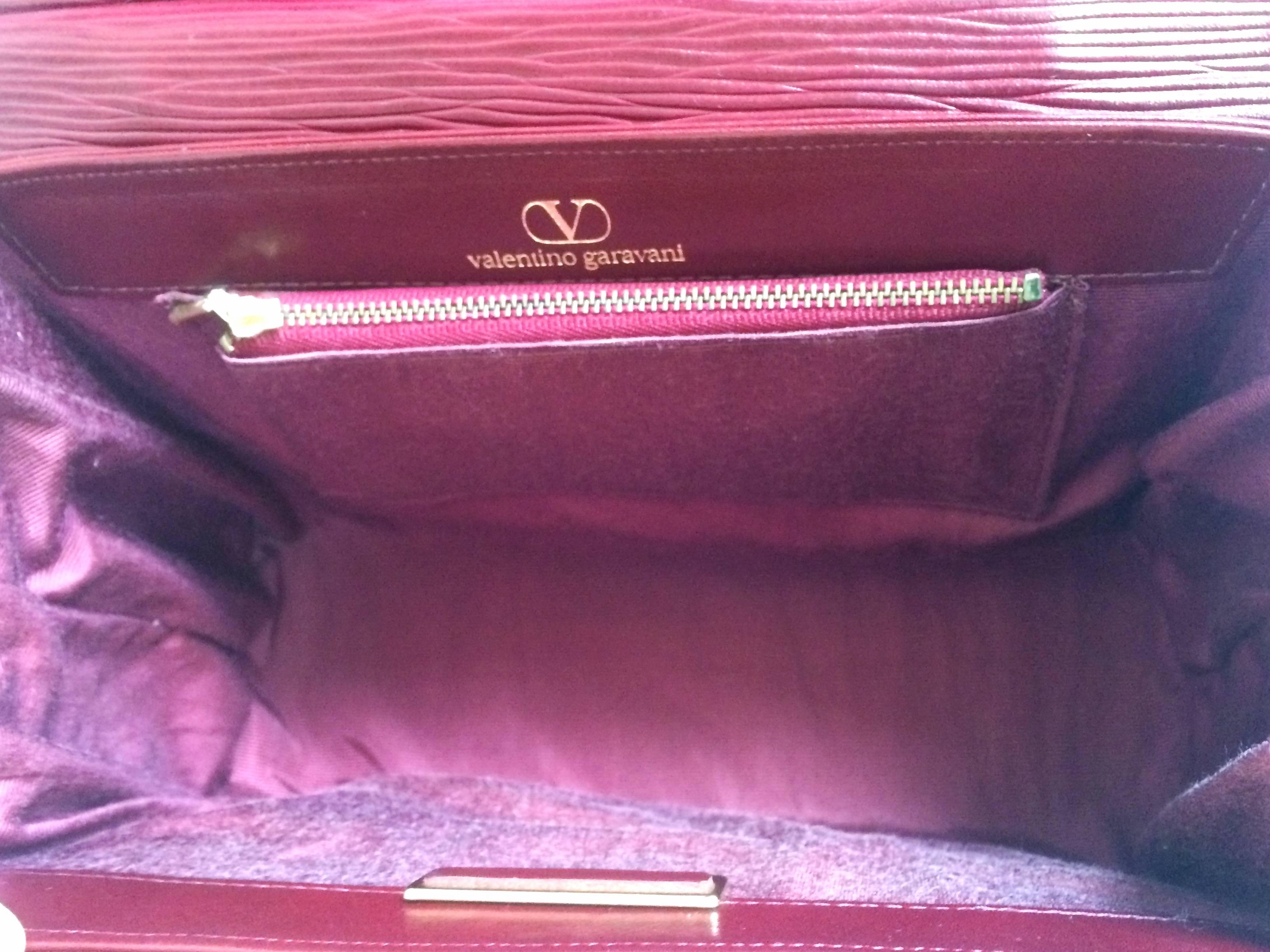 Women's Vintage Valentino Garavani wine epi and smooth leather handbag with buckle flap.