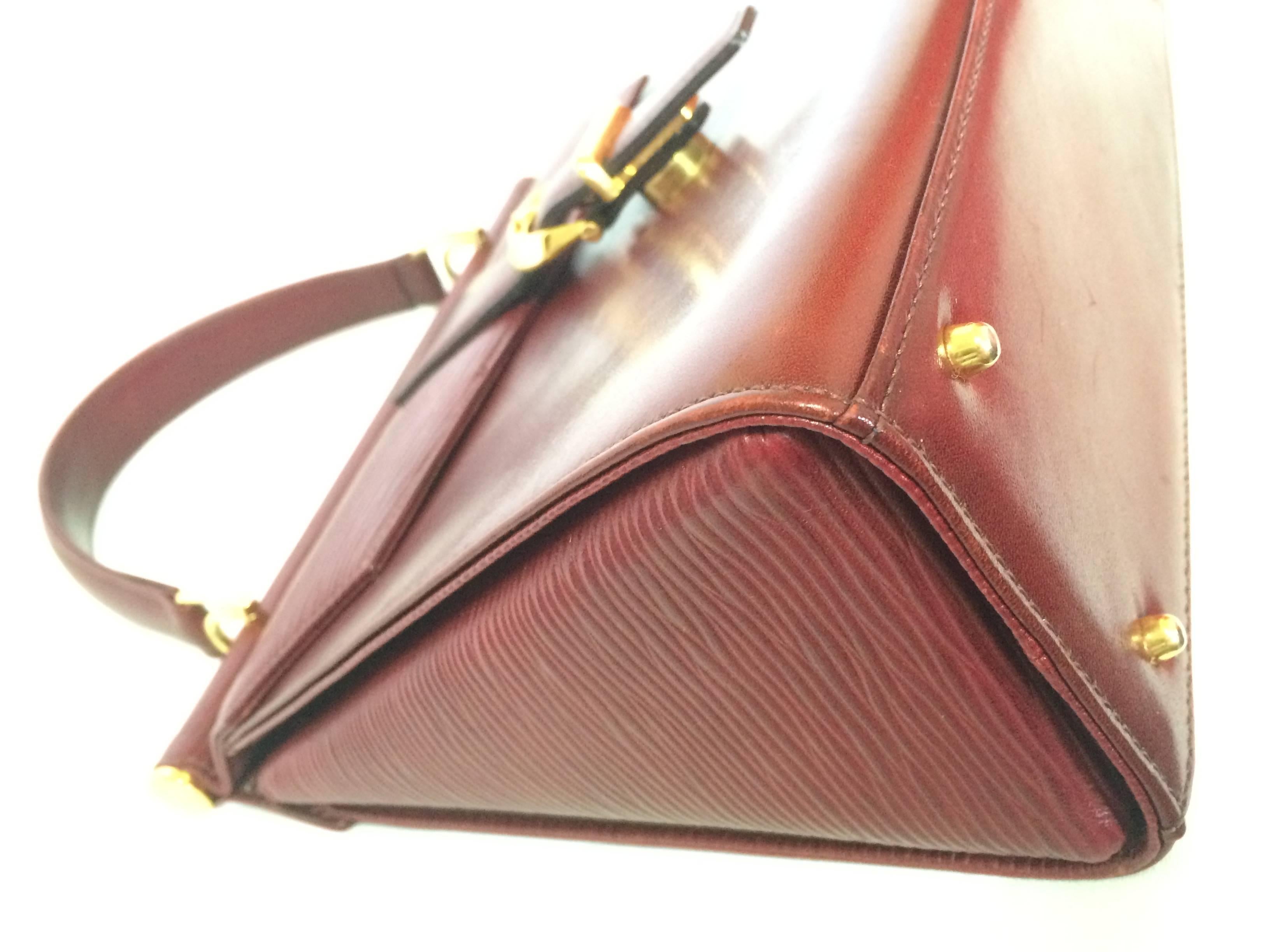 Brown Vintage Valentino Garavani wine epi and smooth leather handbag with buckle flap.