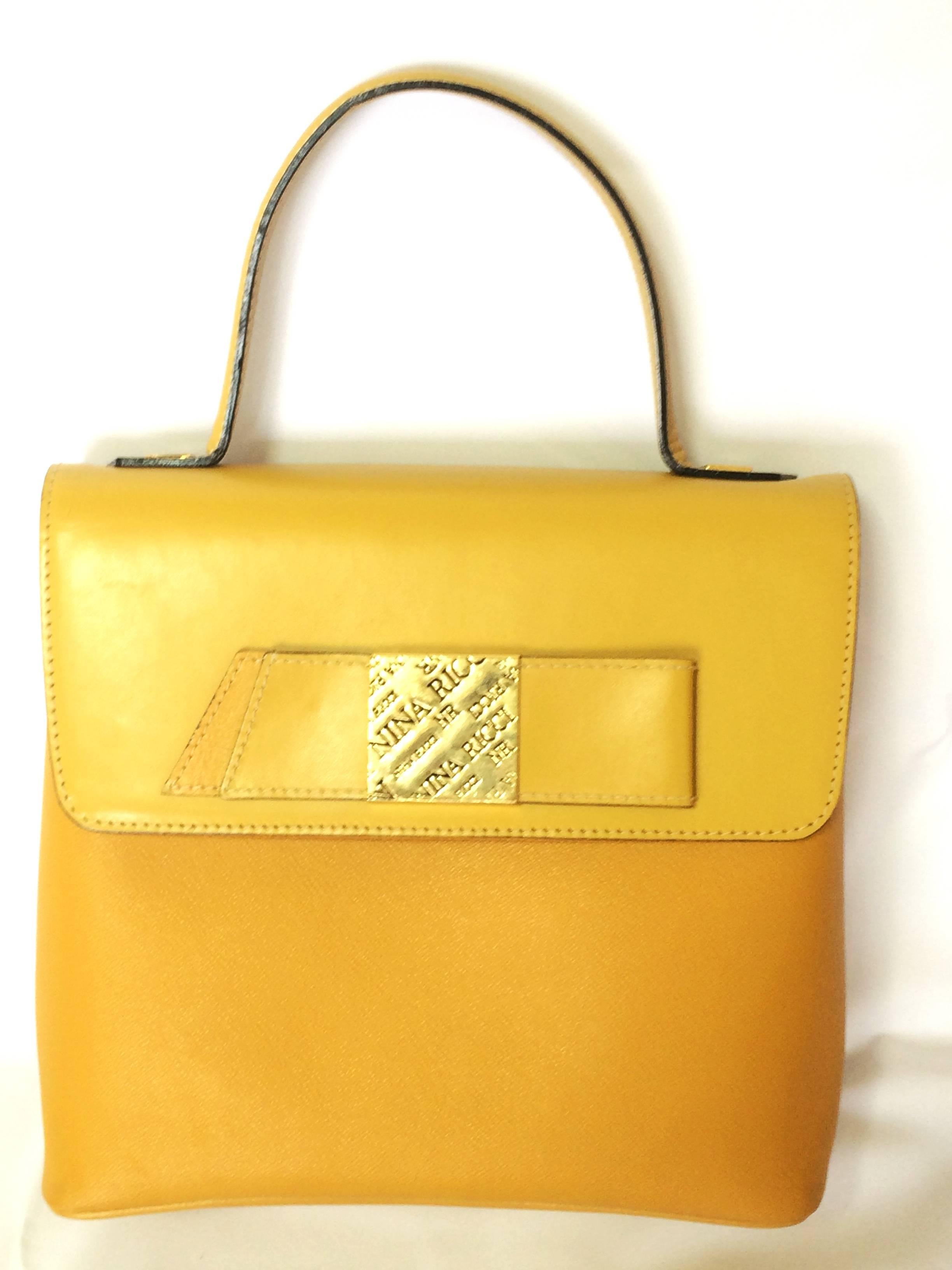 MINT. Vintage Nina Ricci yellow leather handbag purse with shoulder strap and golden logo embossed bow motif. Perfect summer bag.

Introducing a vintage Nina Ricci genuine yellow leather handbag with a detachable shoulder strap back in the 90's.