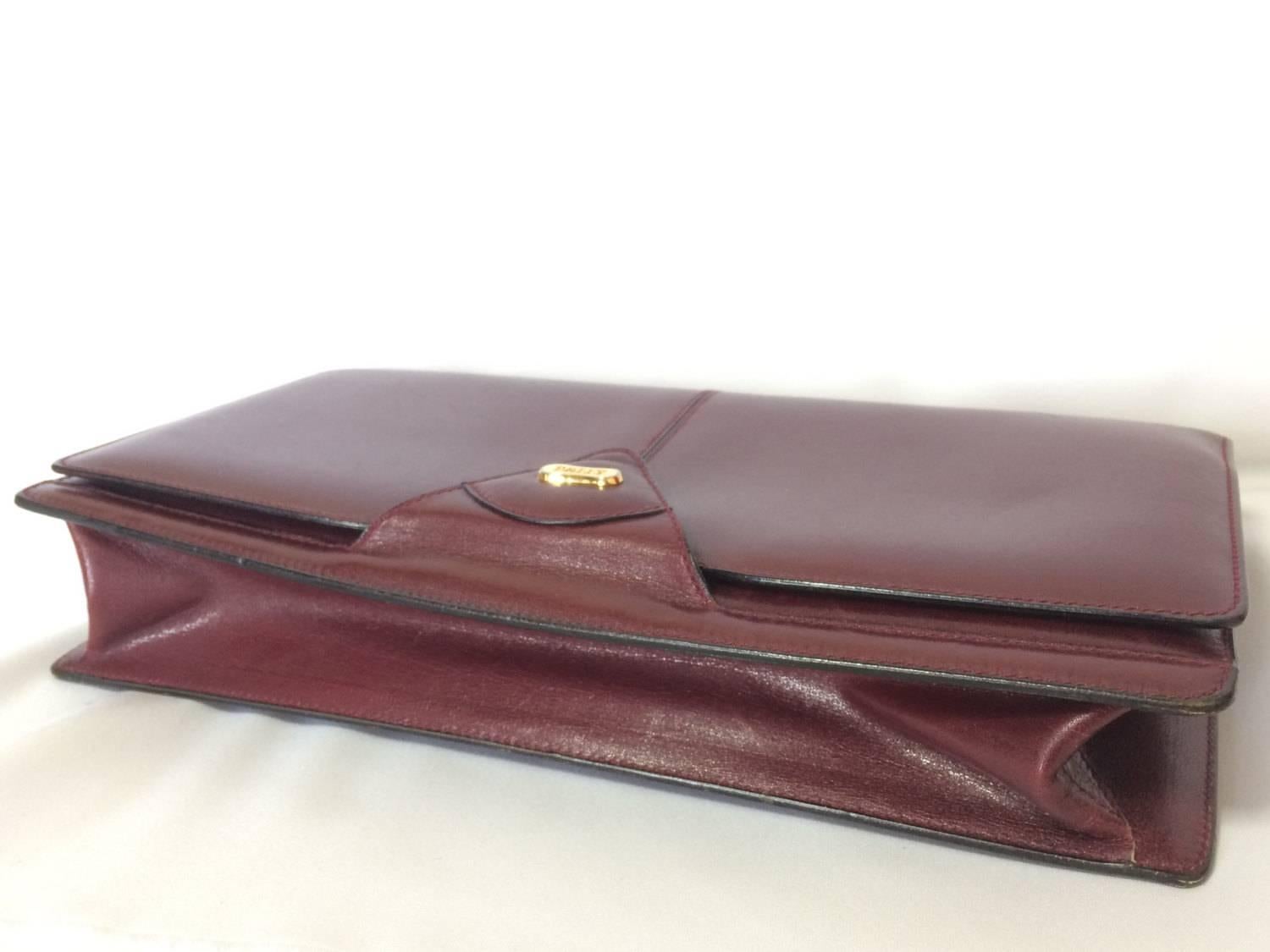 Brown Vintage Bally wine leather clutch bag, party and classic purse with golden logo. For Sale