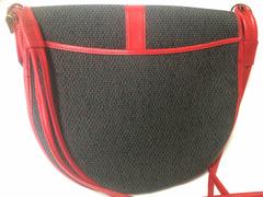 Vintage Yves Saint Laurent oval navy shoulder bag with red shoulder straps.