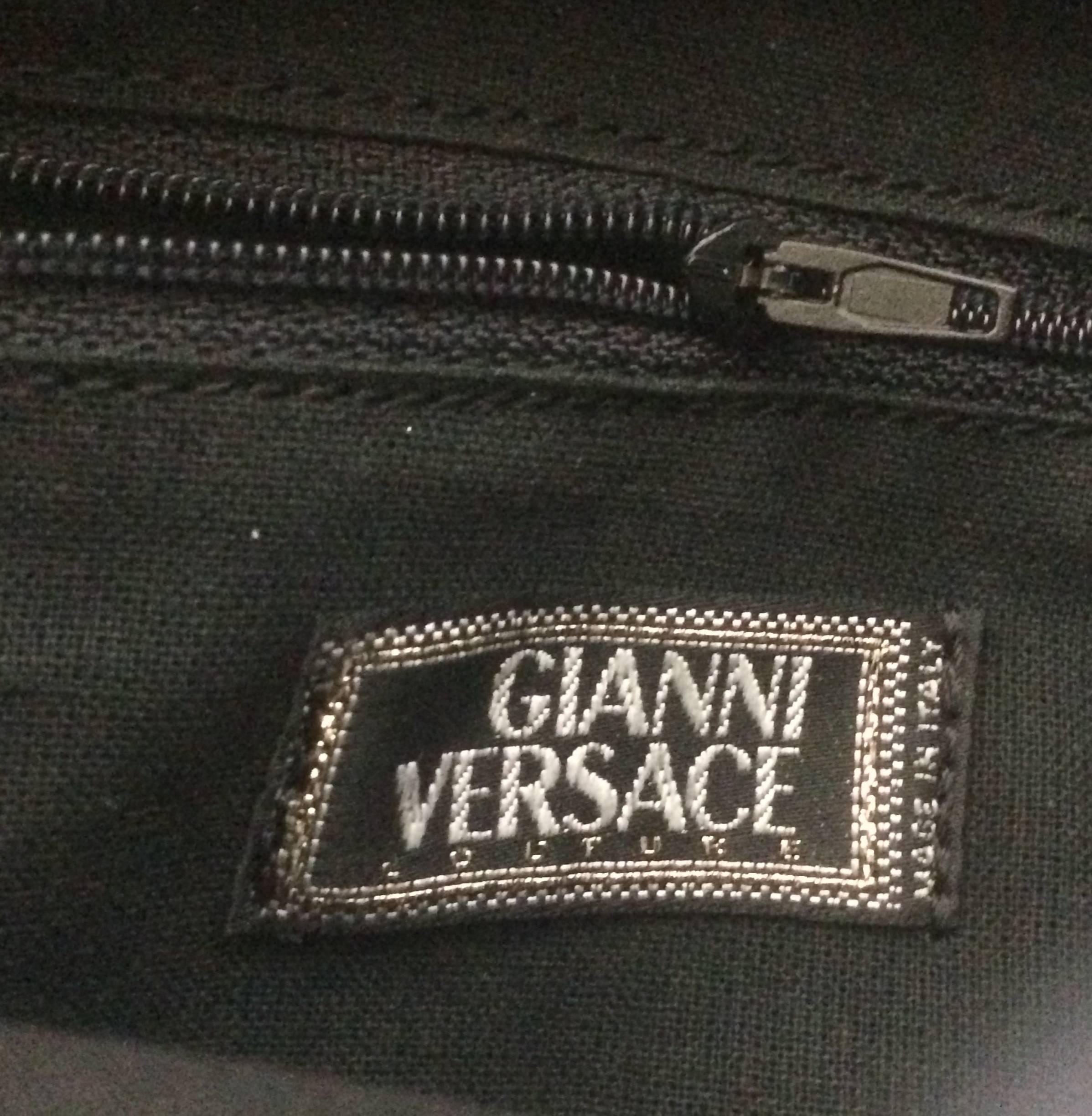 Women's or Men's Vintage Gianni Versace black leather backpack with a big embossed medusa mark.