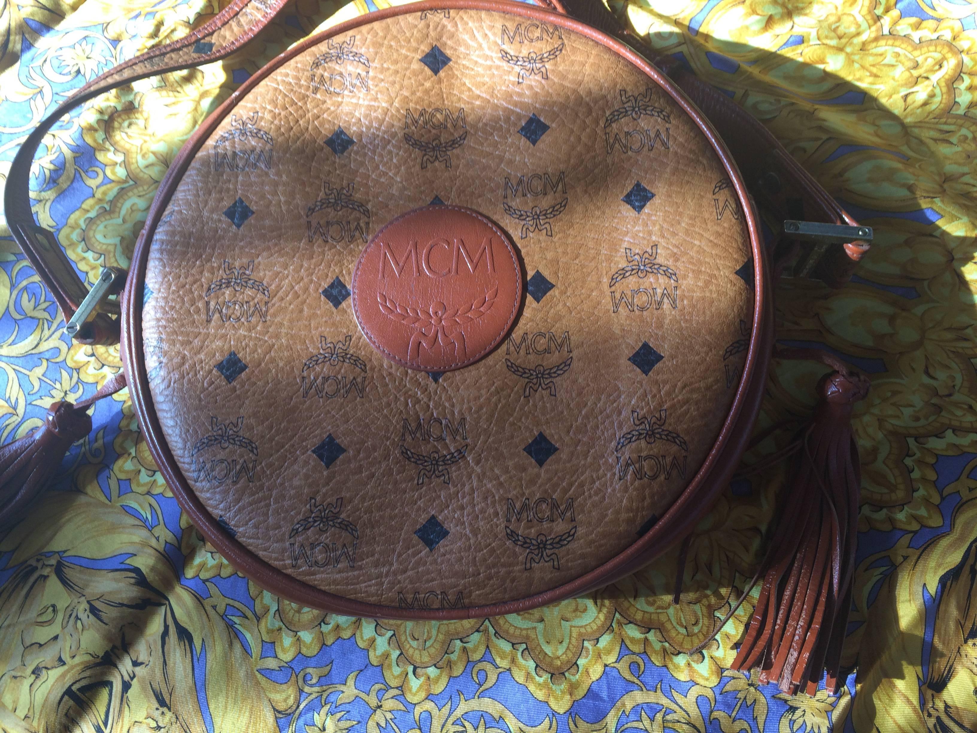 1990s. Vintage MCM rare brown monogram round shape shoulder bag with brown leather trimmings. Designed by Michael Cromer. Masterpiece. Unisex use.

MCM has been back in the fashion trend again!
Now it's considered to be one of the must-have