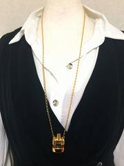 Vintage Gucci golden mini bottle necklace with embossed logo mark and webbing