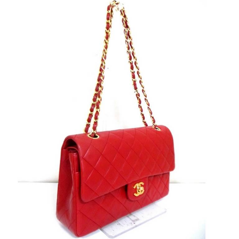 1980s. Vintage CHANEL red lambskin classic medium size 2.55 double flap shoulder bag with golden chain straps. 
Introducing another vintage masterpiece, a classic lamb leather 2.55 double flap purse with gold chain strap from Chanel in the 80's.