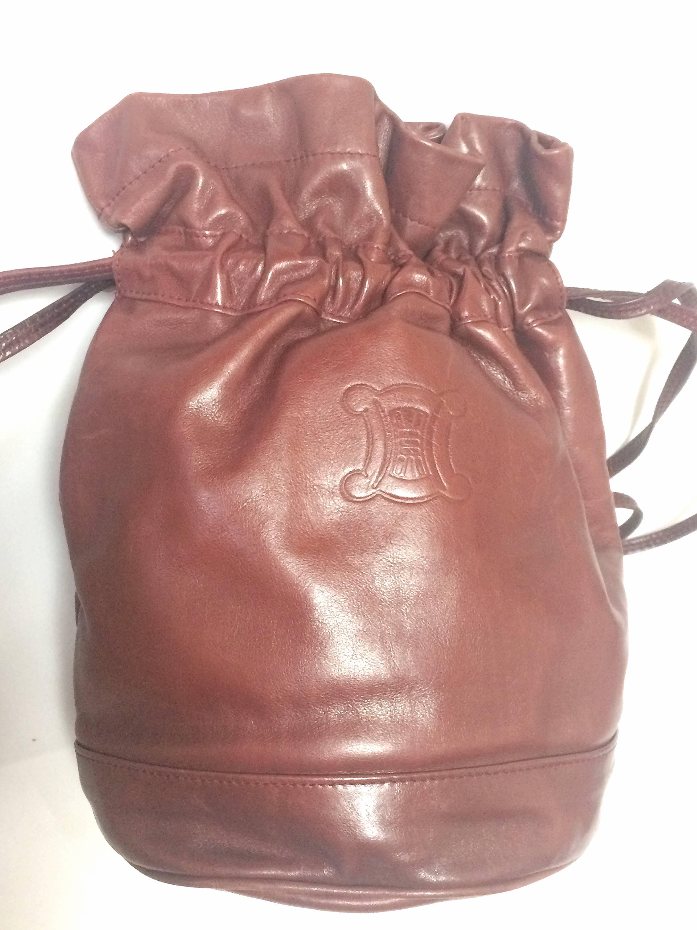 1990s. Vintage Celine wine brown nappa leather hobo bucket shoulder bag with embossed blaion logo at front. Must have masterpiece.

Introducing another masterpiece from CELINE back in the early 90s.
Classic shape bucket hobo shoulder bag in