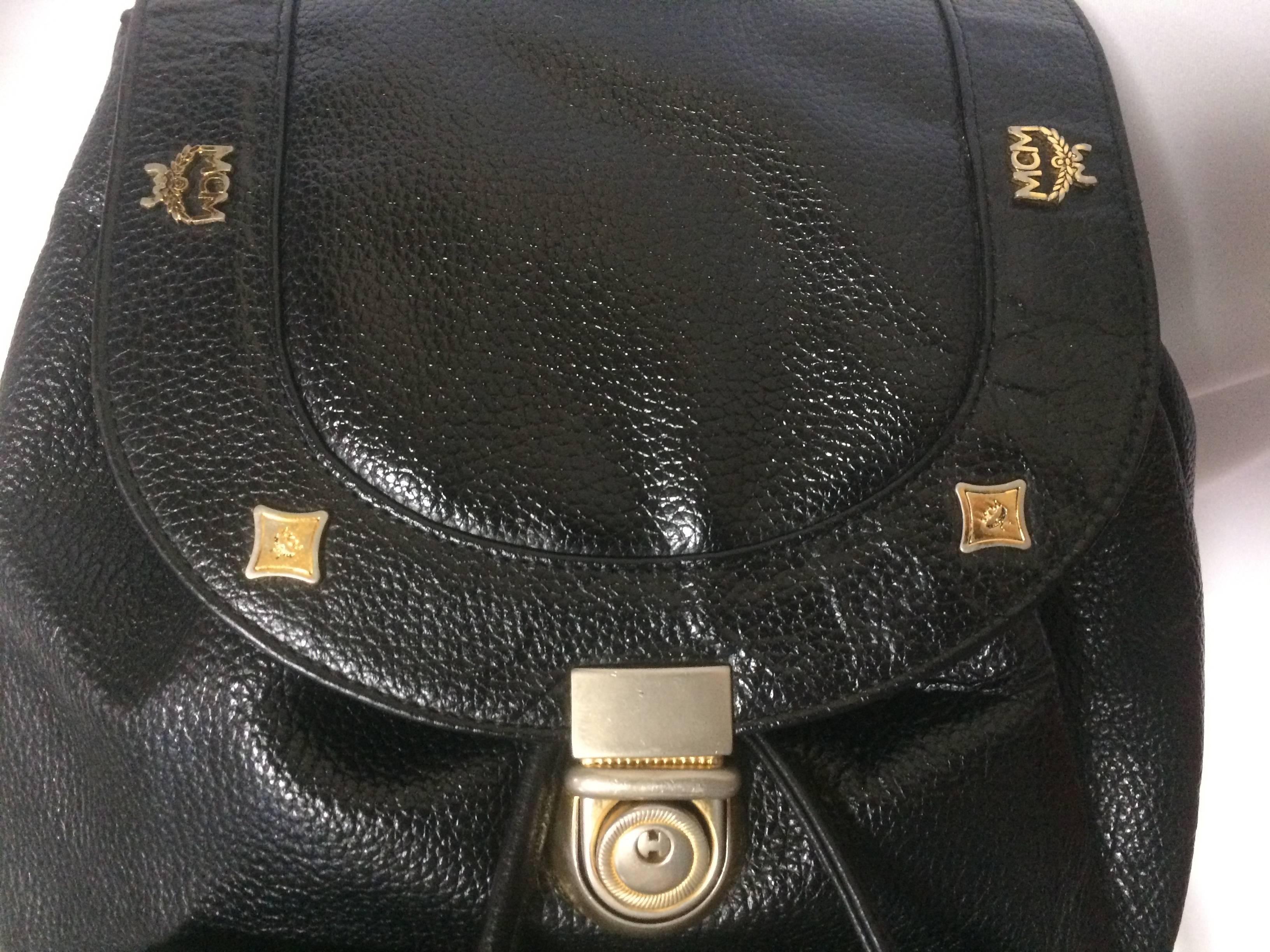 1980s. Vintage MCM genuine leather black backpack with golden studded logo motifs. Designed by Michael Cromer. Unisex bag for daily use.

MCM has now come back in trend and so hot in the market!!

This is the vintage MCM black genuine leather