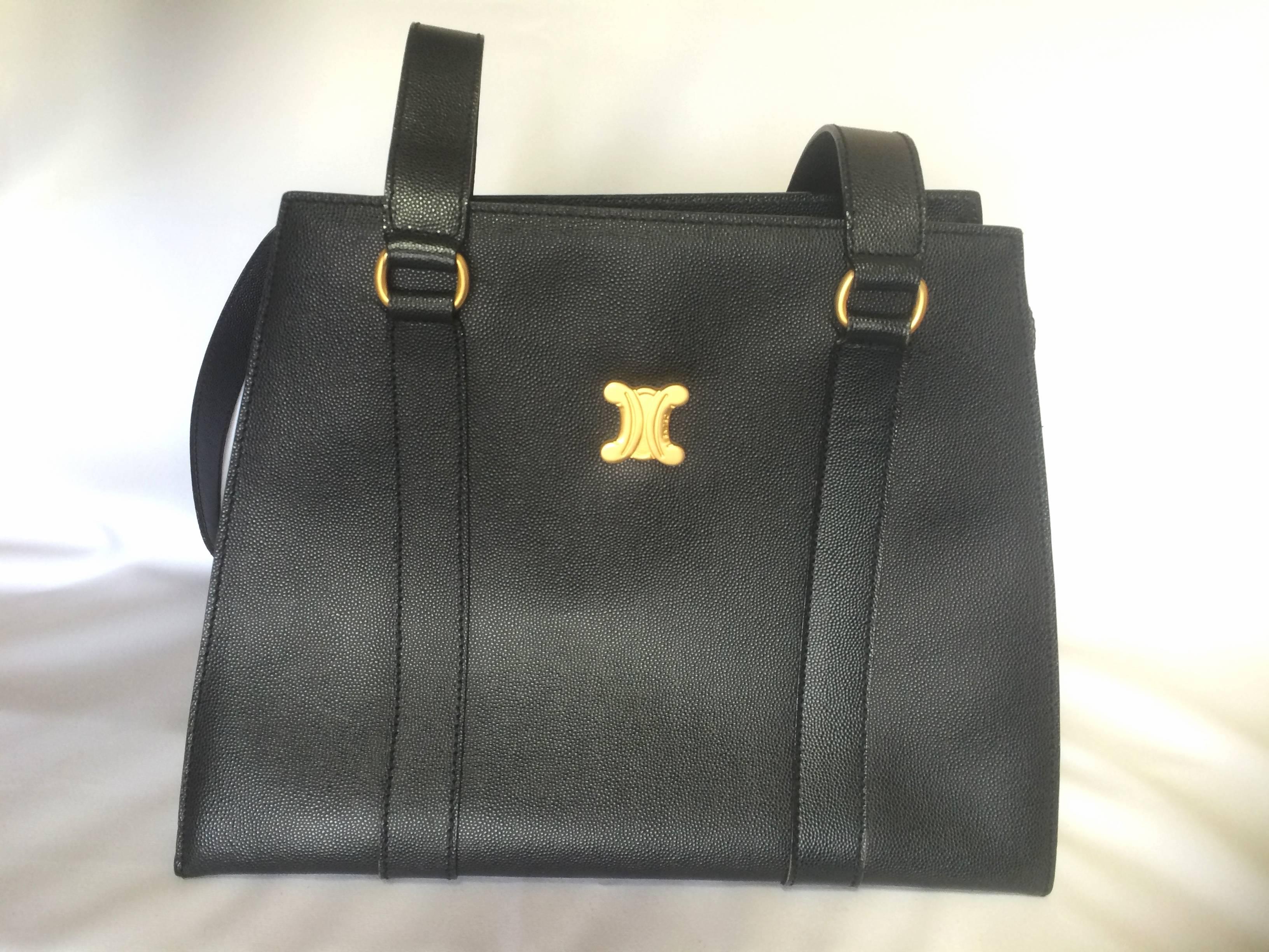 1990s. Vintage CELINE black trapezoidal tote with red lining and gold tone Celine logo charm.

Here is another rare vintage CELINE tote from approx early 90s. The trapezoidal shape is unique and can hold many things. Great for work as well!
You