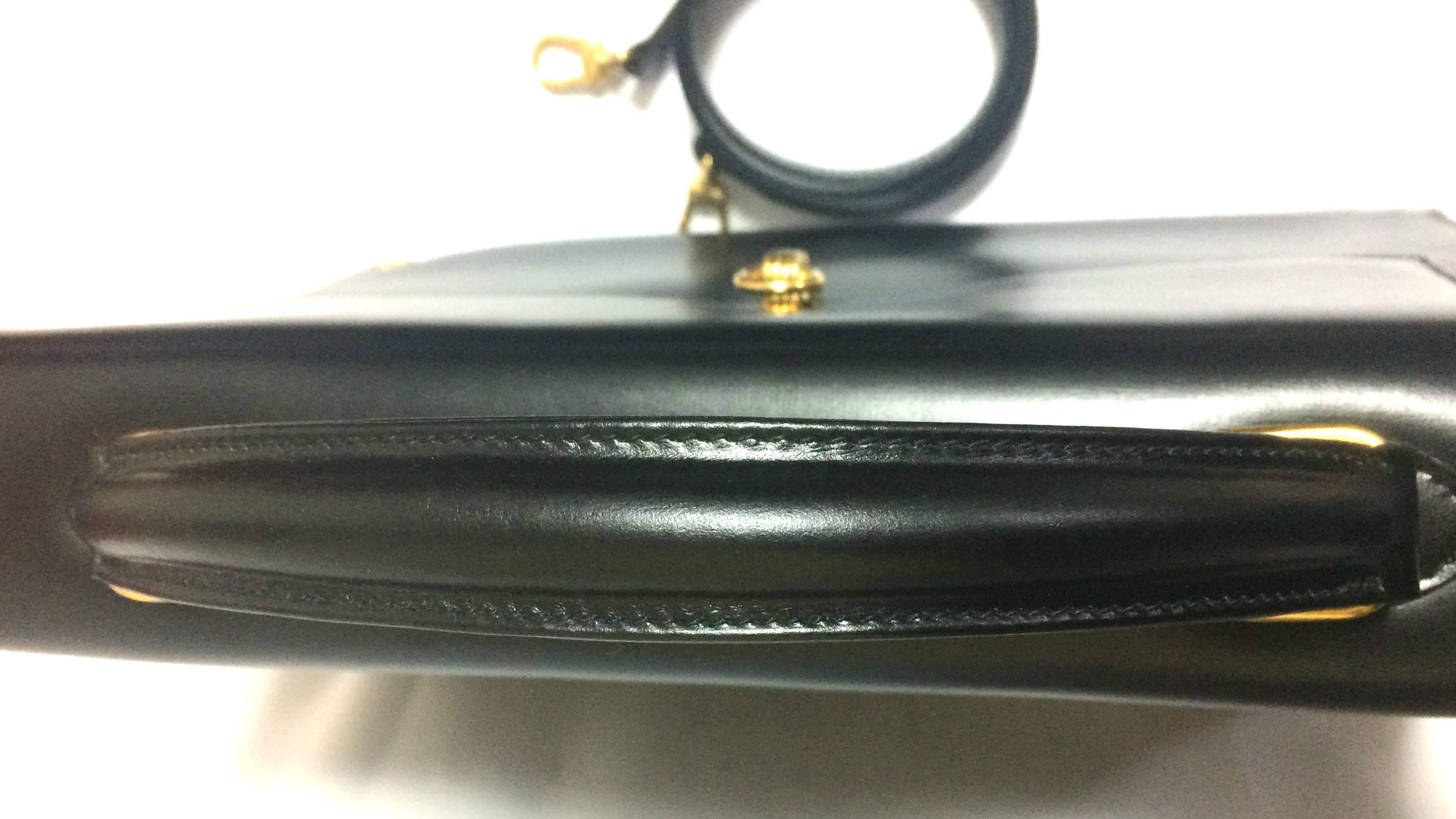 Women's Vintage Roberta di Camerino black Kelly bag with golden logo and shoulder strap.