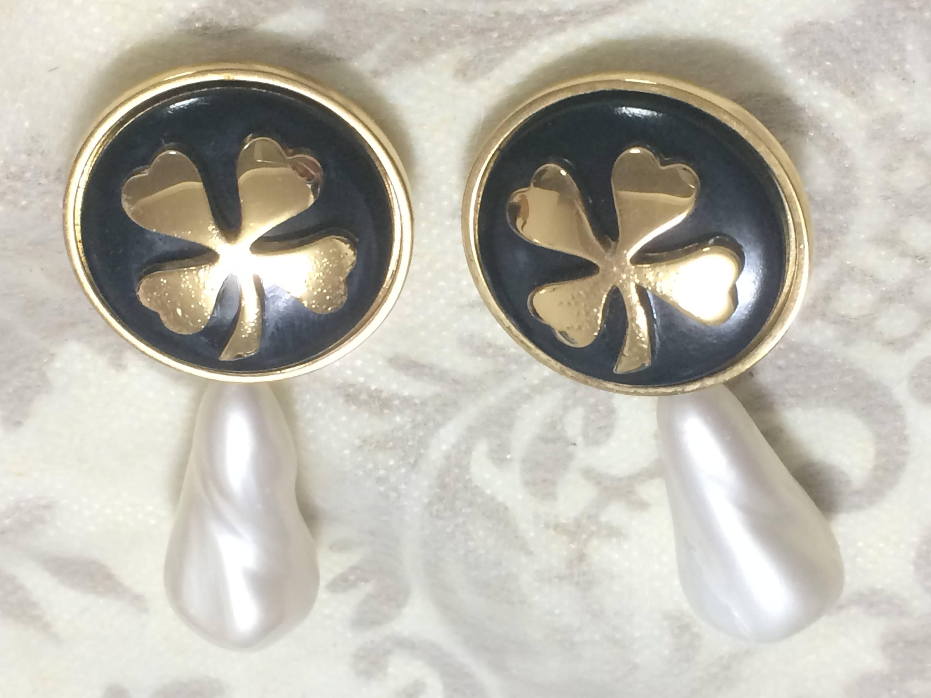 1990s. Vintage CHANEL white teardrop faux pearl earring with black and gold clover motif. Dangling earrings in large size.

Introducing a vintage CHANEL teardrop faux pearl earrings with black and golden clover marks that dangle as you