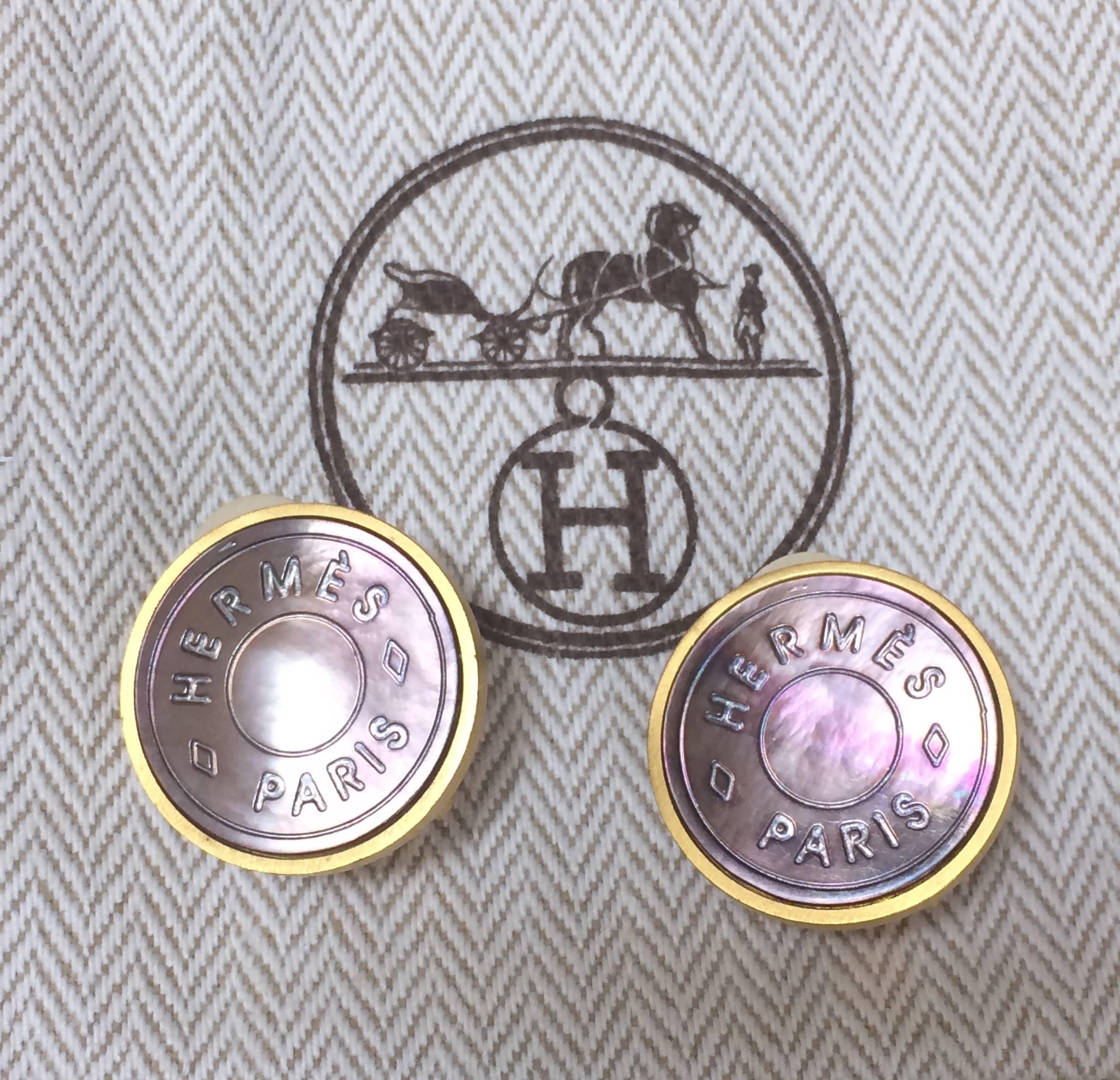 1990s. Vintage HERMES golden logo embossed genuine shell earrings. Classic jewel piece. Bijouterie Fantaisie.

Introducing a vintage FAB masterpiece jewelry, golden round earrings with genuine shell from Hermes, BIJOUTERIE FANTAISIE.
The logo is