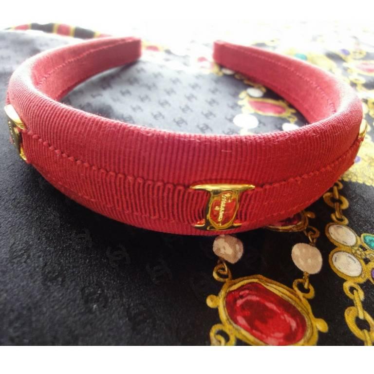 1990s. Vintage Salvatore Ferragamo vara collection, golden logo embossed charm red hair accessory, head band.

Here is another fabulous piece for head from Salvatore Ferragamo back in the era.
This is a hair band featuring gold tone logo embossed