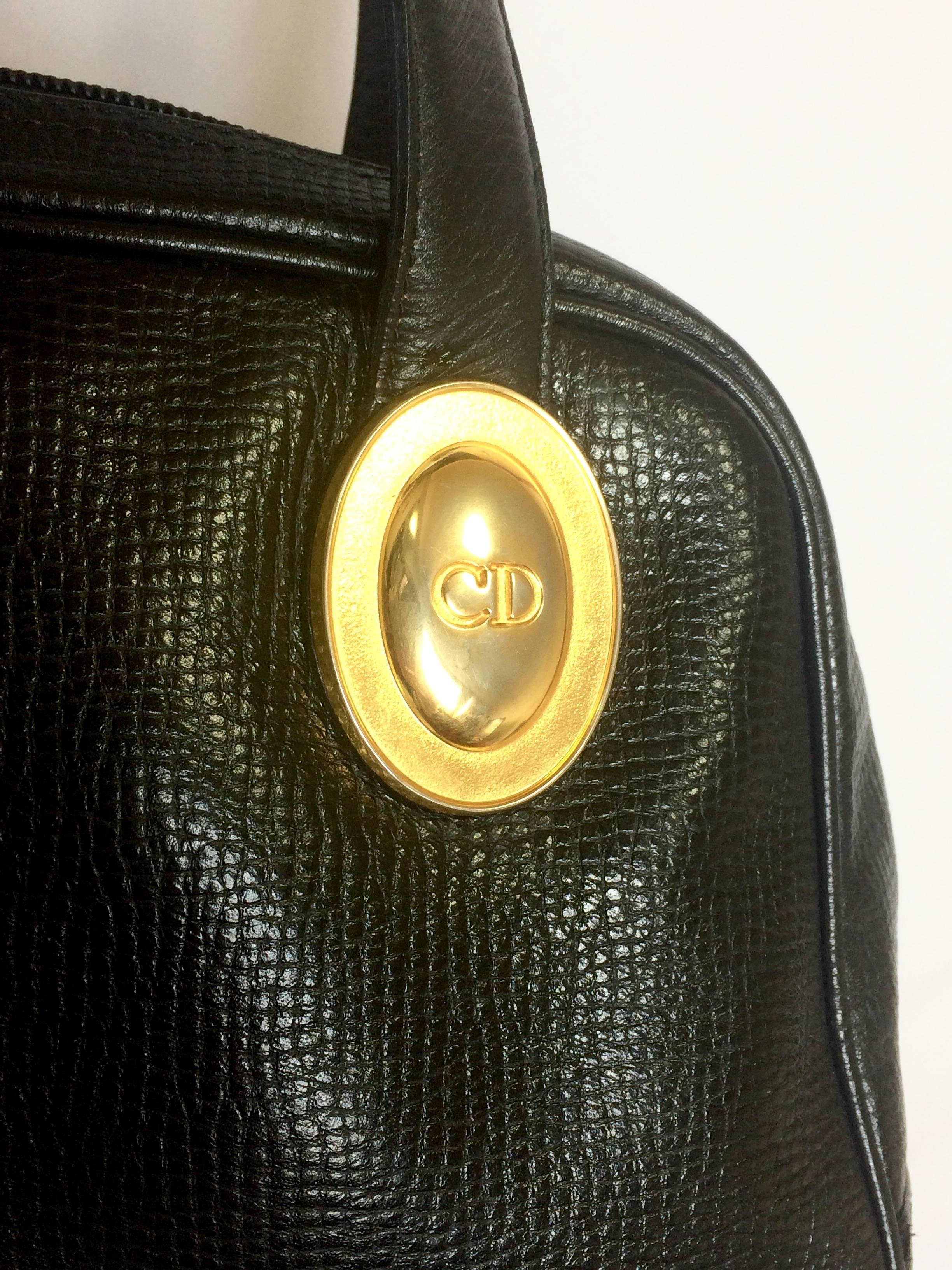 1990s. Vintage Christian Dior black grained leather mini bolide style handbag with oval golden CD logo motif. Classic style bag for daily use.

1990s. Vintage Christian Dior black grained leather mini bolide style handbag with oval golden CD logo
