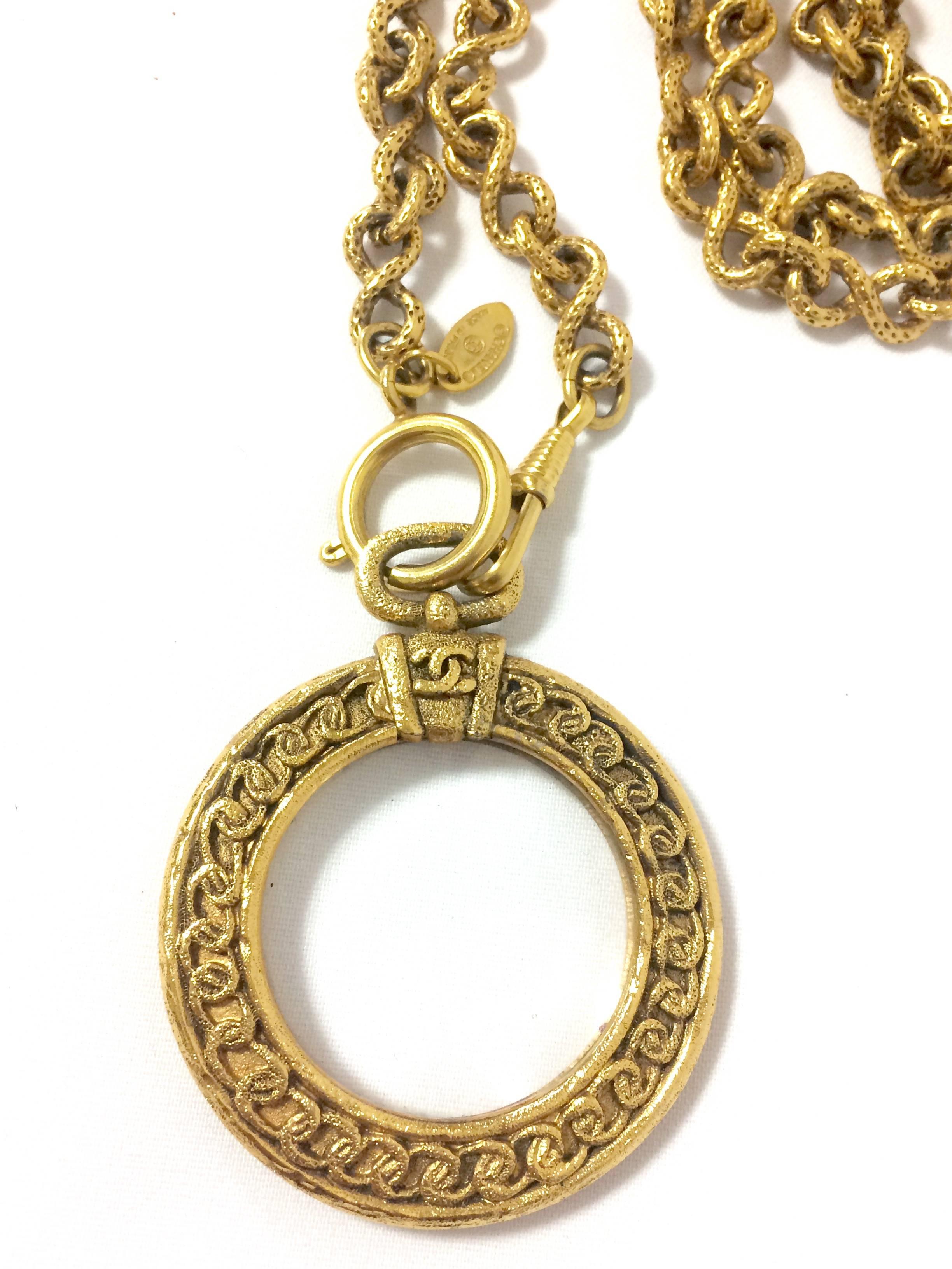 Women's Vintage CHANEL long chain necklace with round glass loupe pendant top and CC.