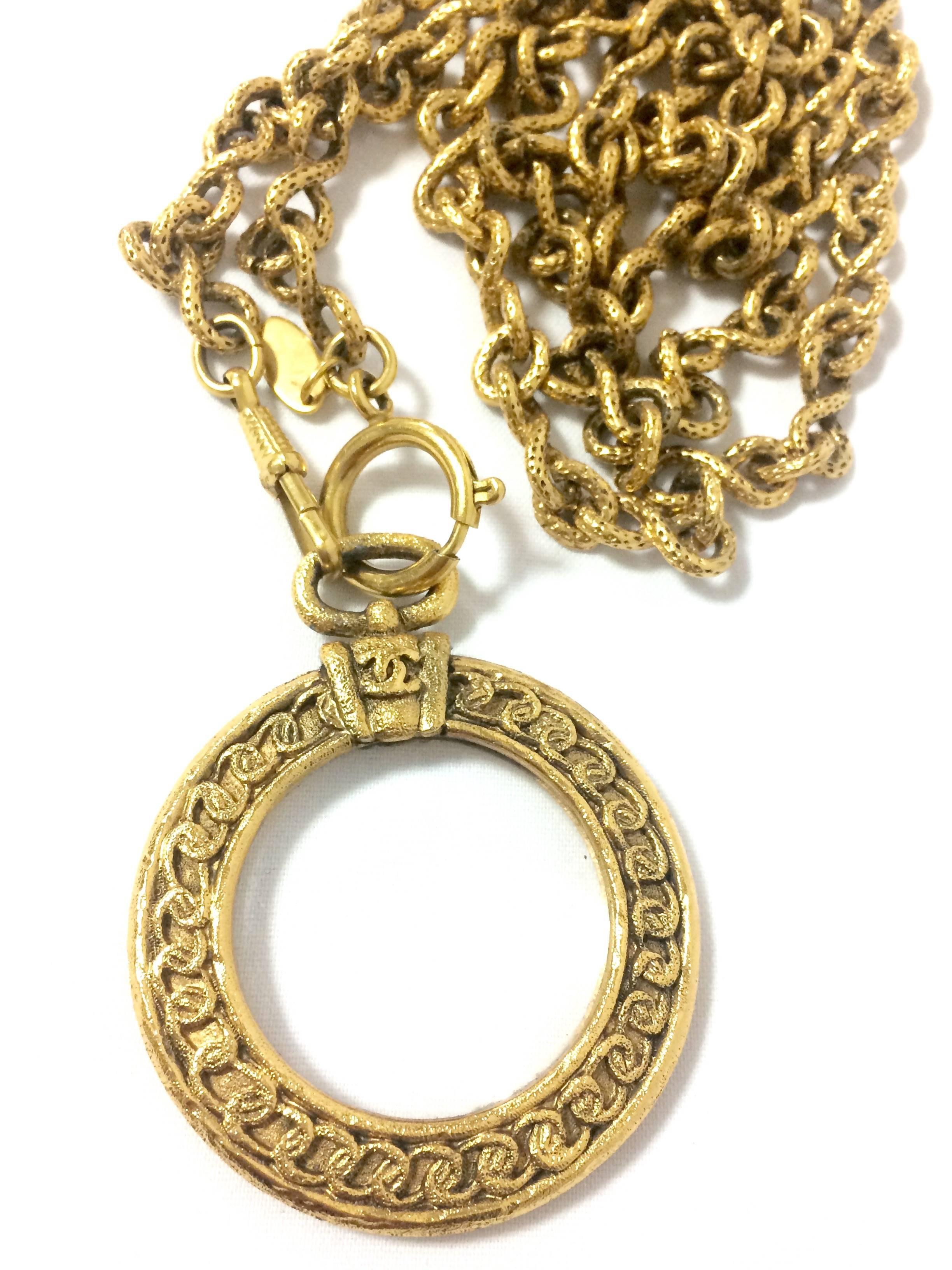 Vintage CHANEL long chain necklace with round glass loupe pendant top and CC. 1