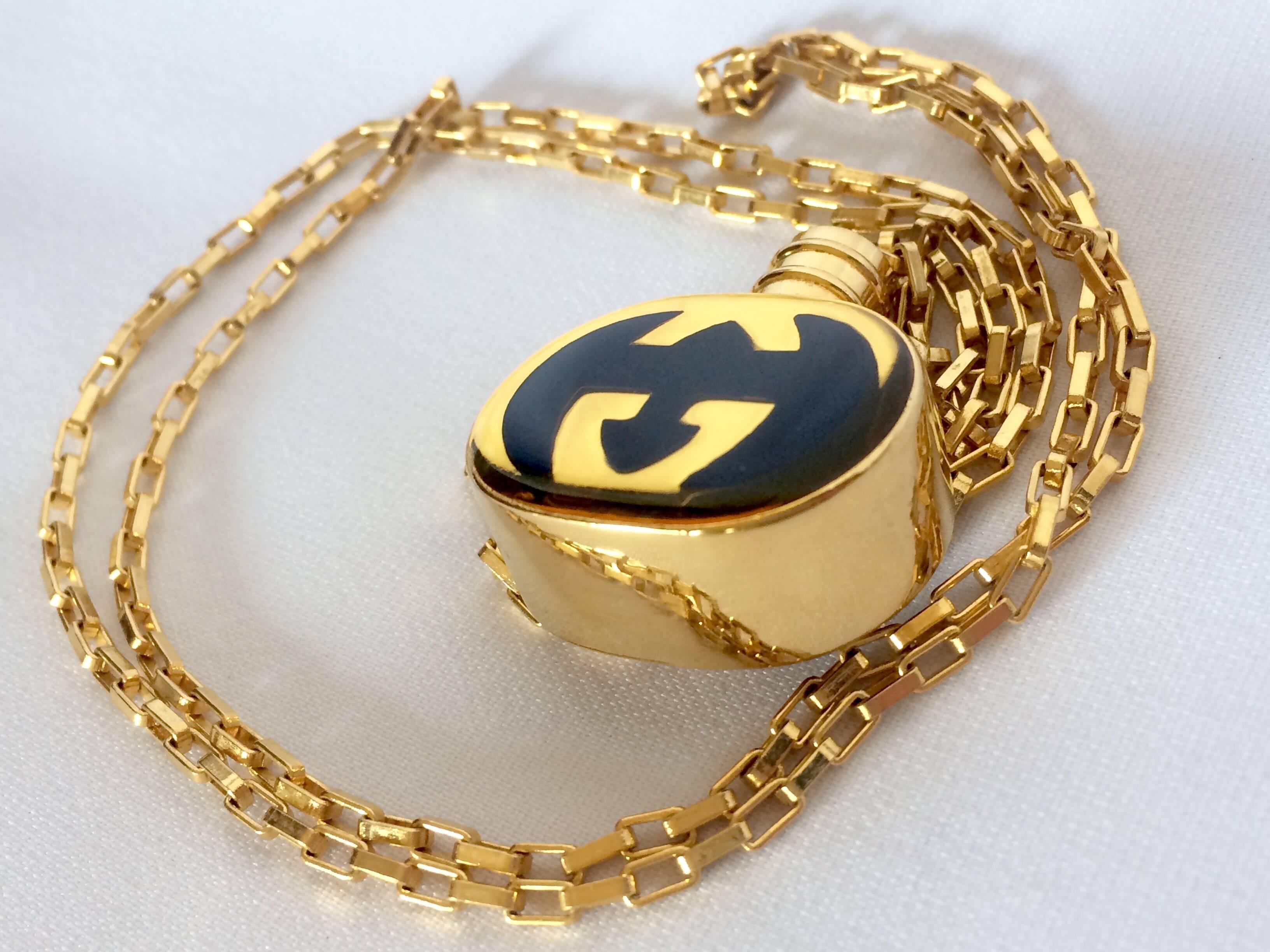 Women's Vintage Gucci gold and navy round shape perfume bottle necklace with logo mark.
