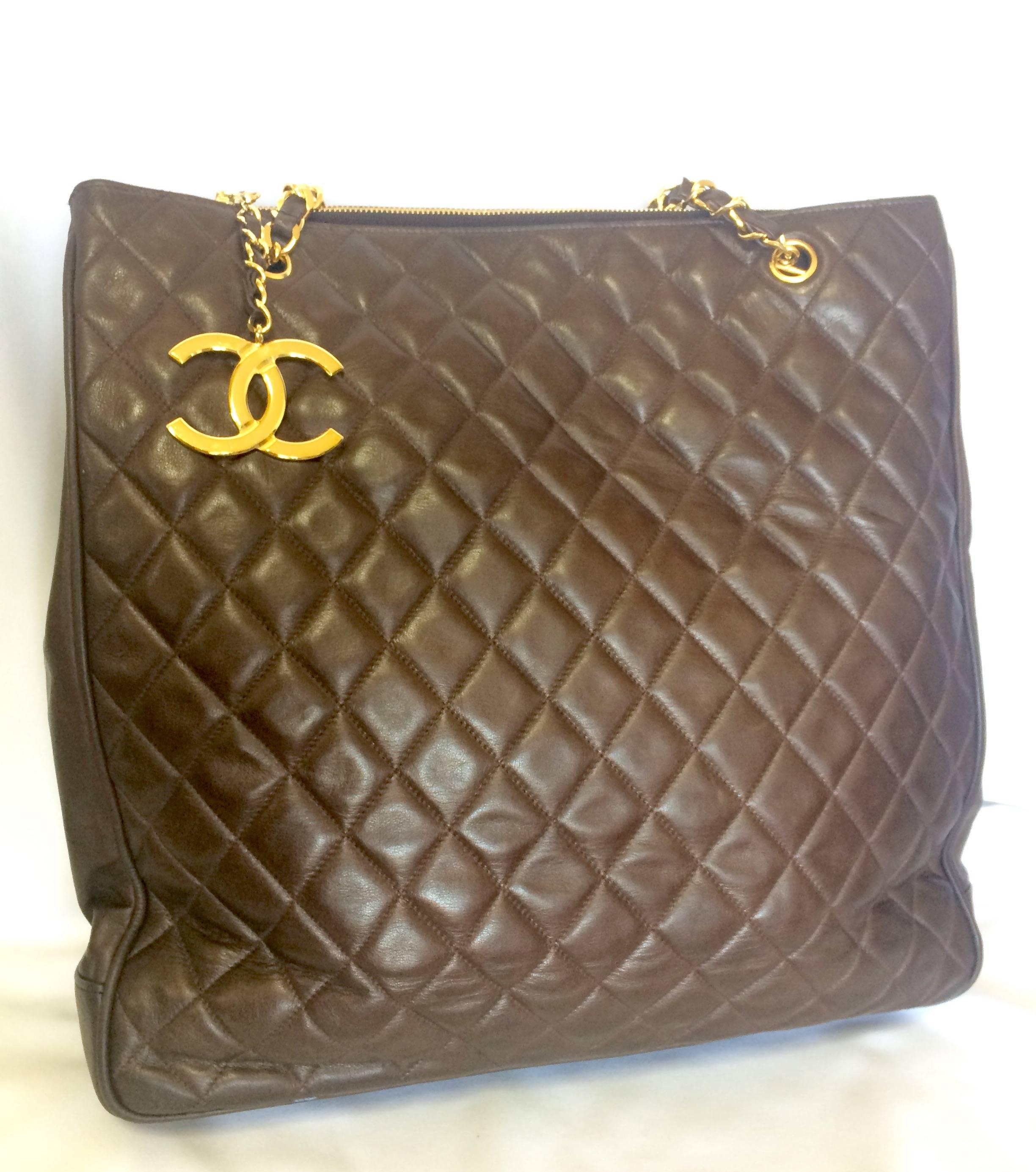 1990s. Vintage CHANEL brown lambskin large tote bag with gold tone chains and jumbo CC mark charm to the LAMPO zipper. Classic purse.

Introducing a vintage CHANEL brown color lamb leather large tote bag from the early 90's.

Featuring its iconic