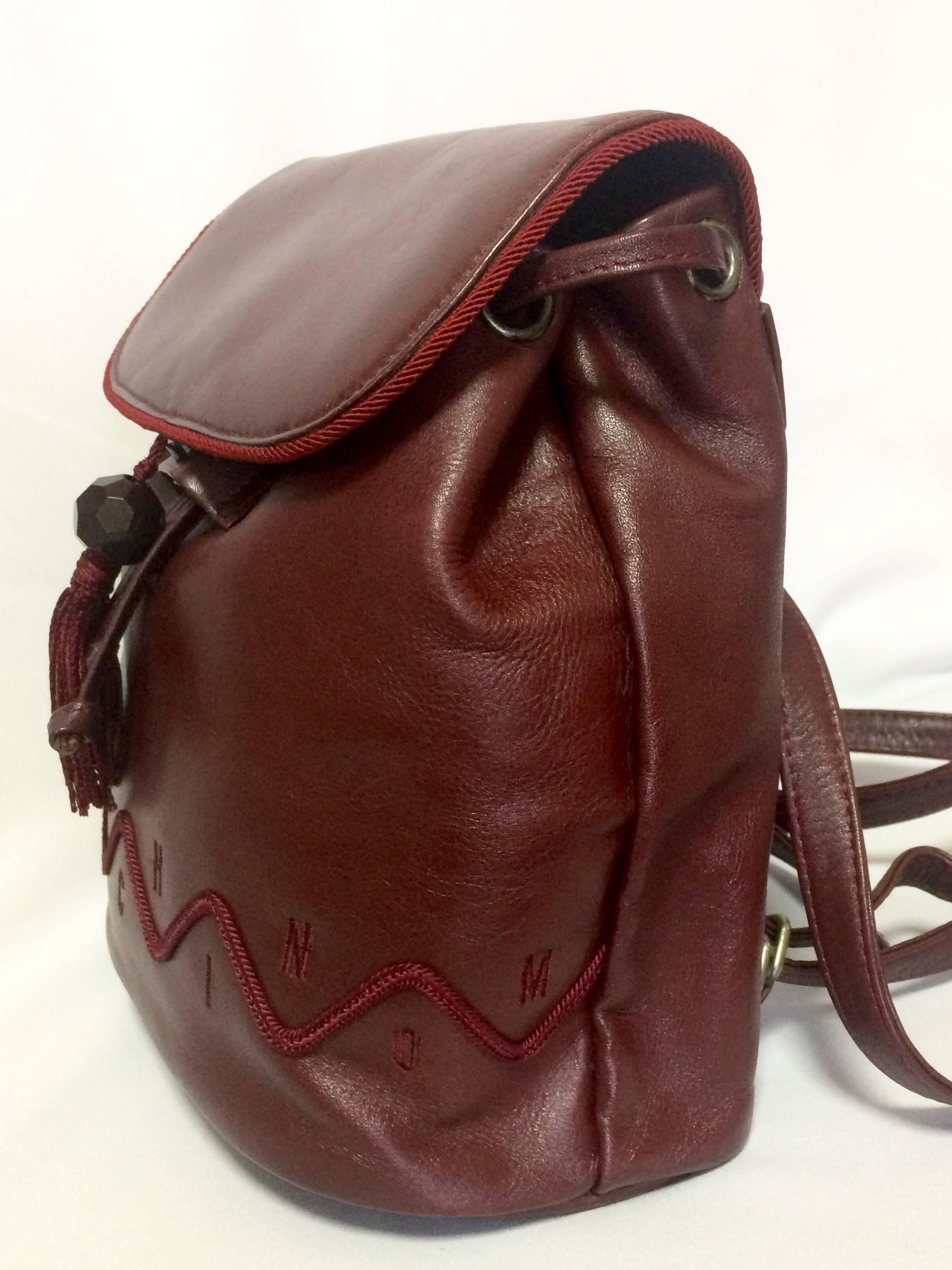 Women's Vintage MOSCHINO dark wine leather backpack with tassel and logo embroidery. For Sale