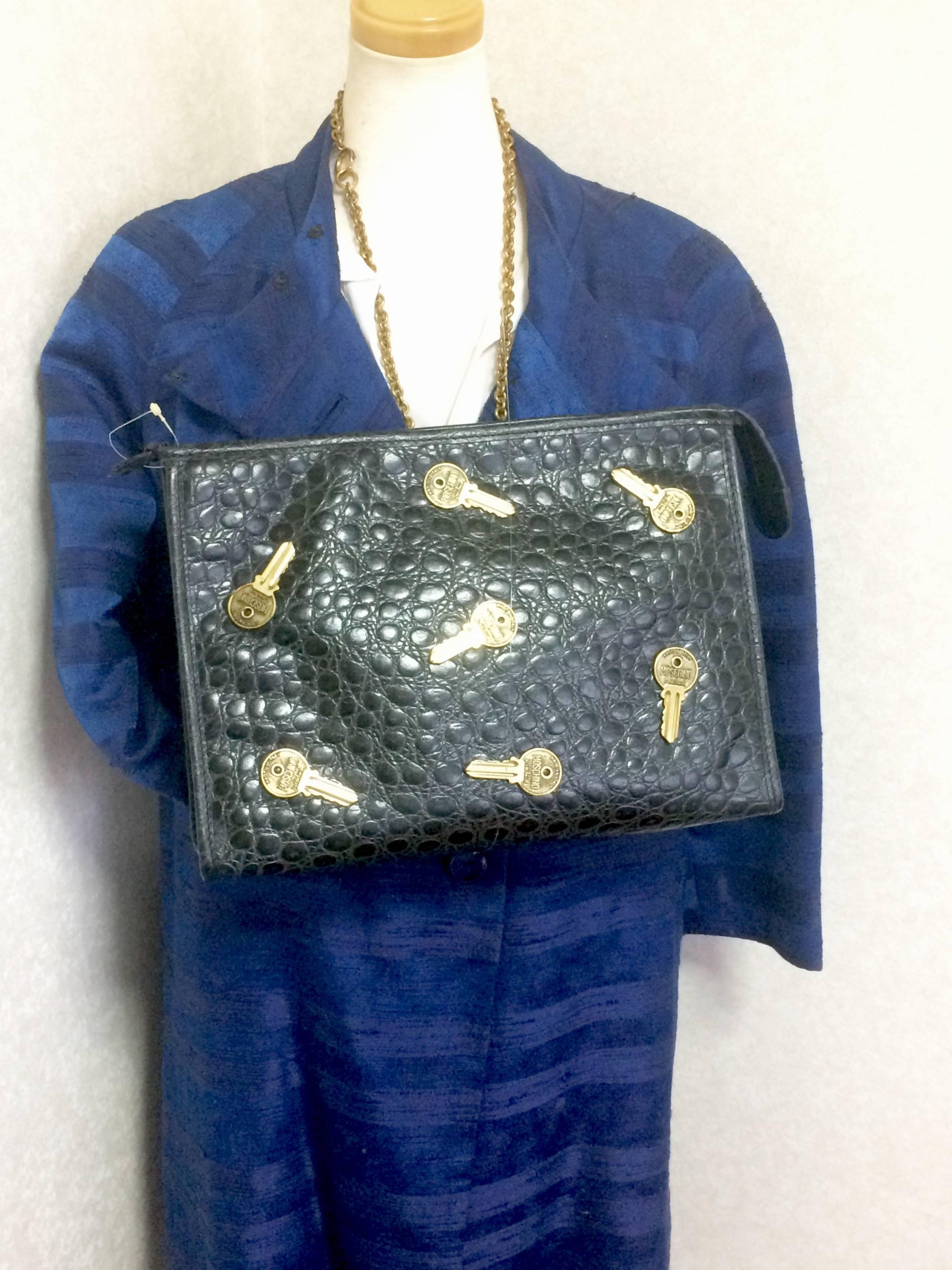 1990s. Vintage MOSCHINO classic croc-embossed black leather clutch bag with key logo motifs all over. Masterpiece produced by Red Wall.

This is one of the coolest masterpieces produced by Red Wall, made in Italy. 
Can be unisex use.

Cute vintage