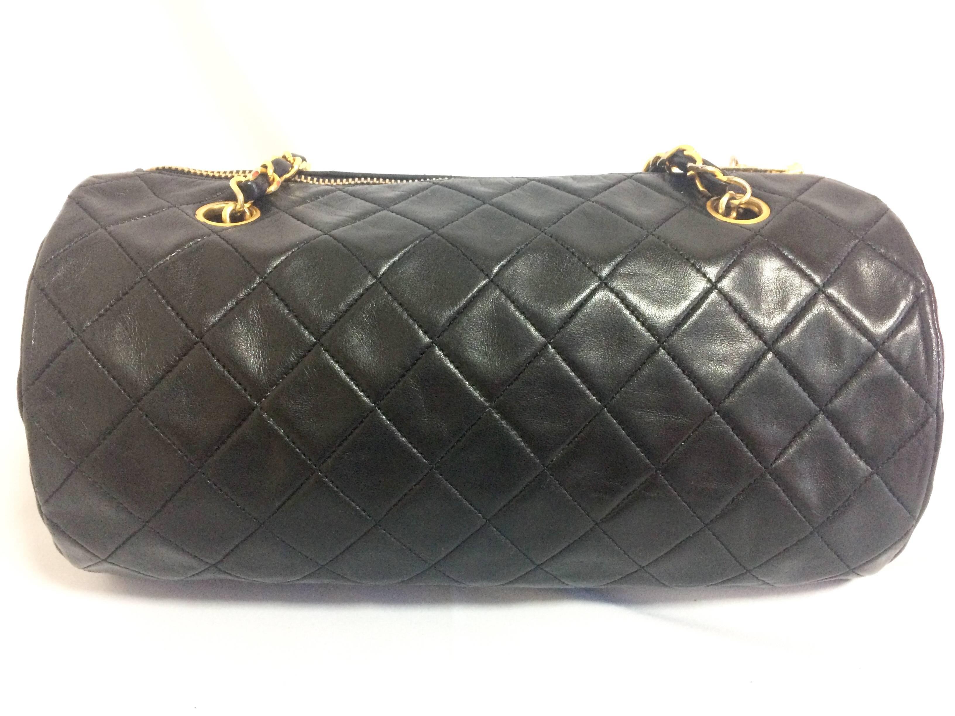 Black Vintage CHANEL black lamb leather golden chain shoulder bag in round drum shape.