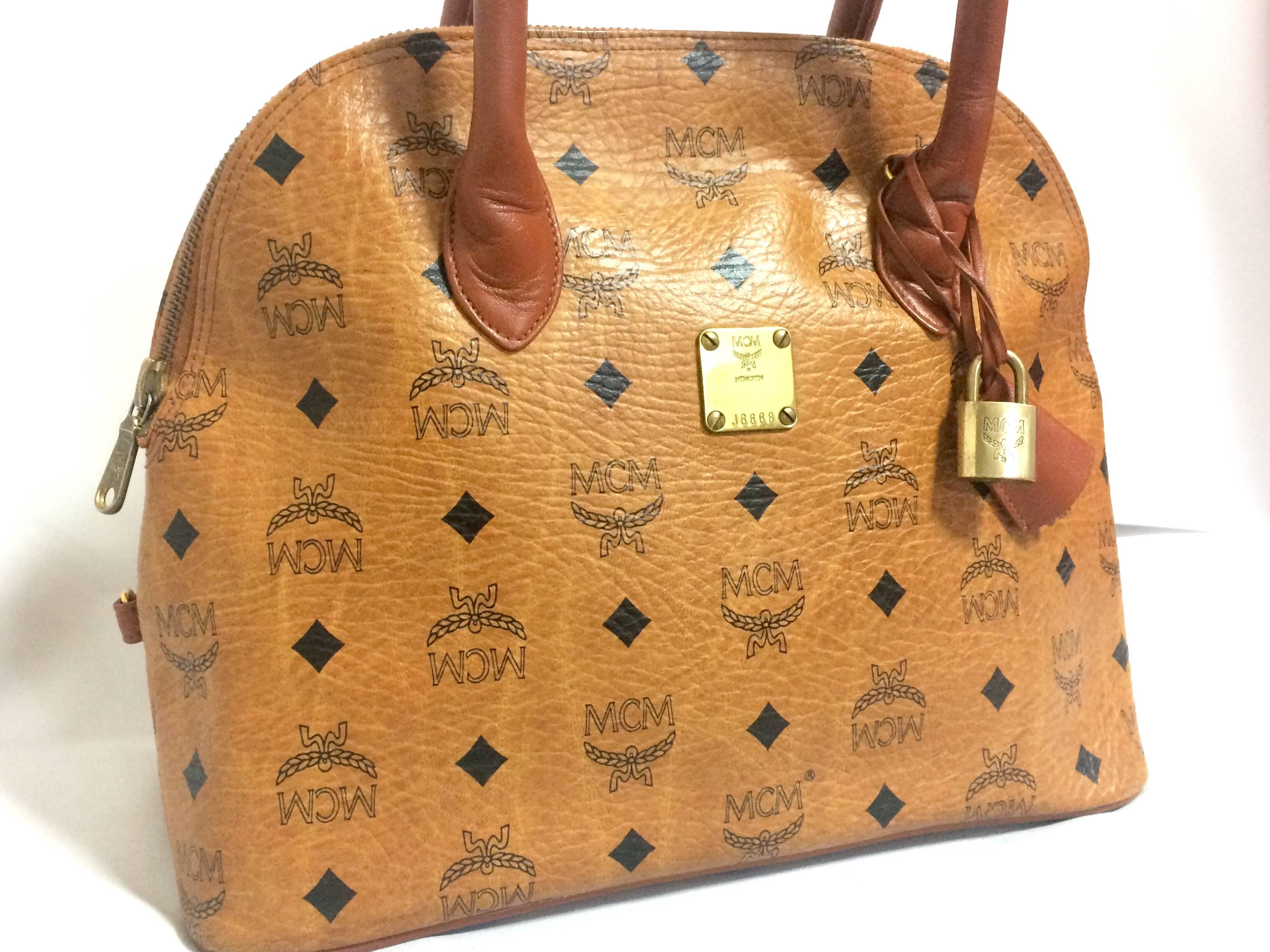 1990s. Vintage MCM classic brown monogram handbag in bolide design. Classic bag designed by Michael Cromer. Handmade in Germany.

MCM has been back in the fashion trend again!!
Now it's considered to be one of the must-have designer in